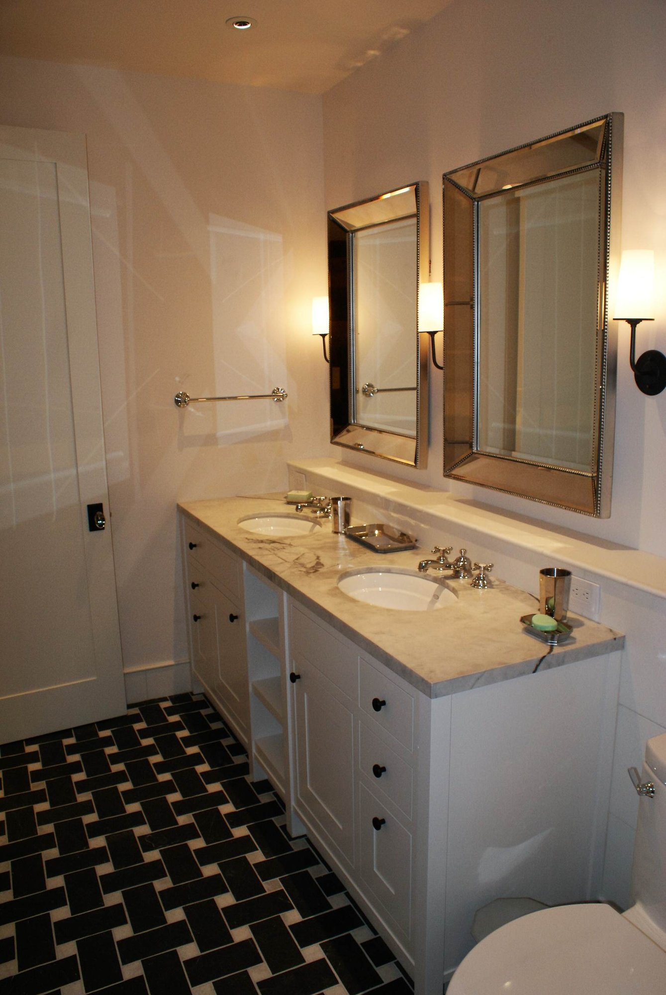 Mid-sized transitional 3/4 porcelain tile bathroom with shaker cabinets, white cabinets, a one-piece toilet, white walls, marble countertops and an undermount sink, by Jensen Design in Telluride, CO