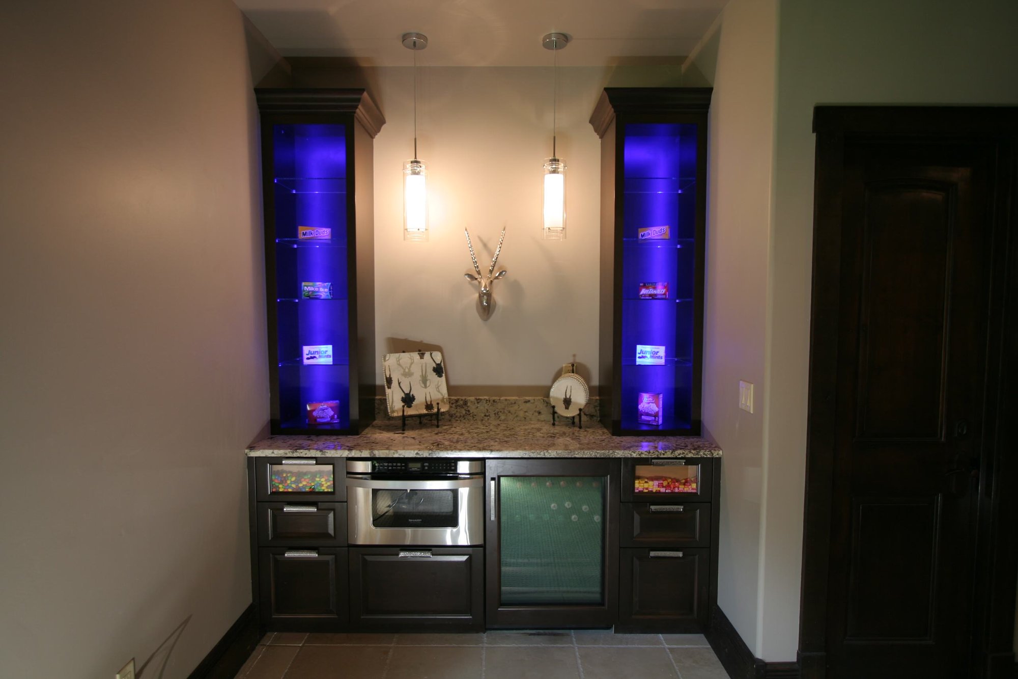 Small transitional single-wall ceramic tile wet bar with raised-panel cabinets, dark wood cabinets and granite countertops, by Jensen Design in Telluride, CO