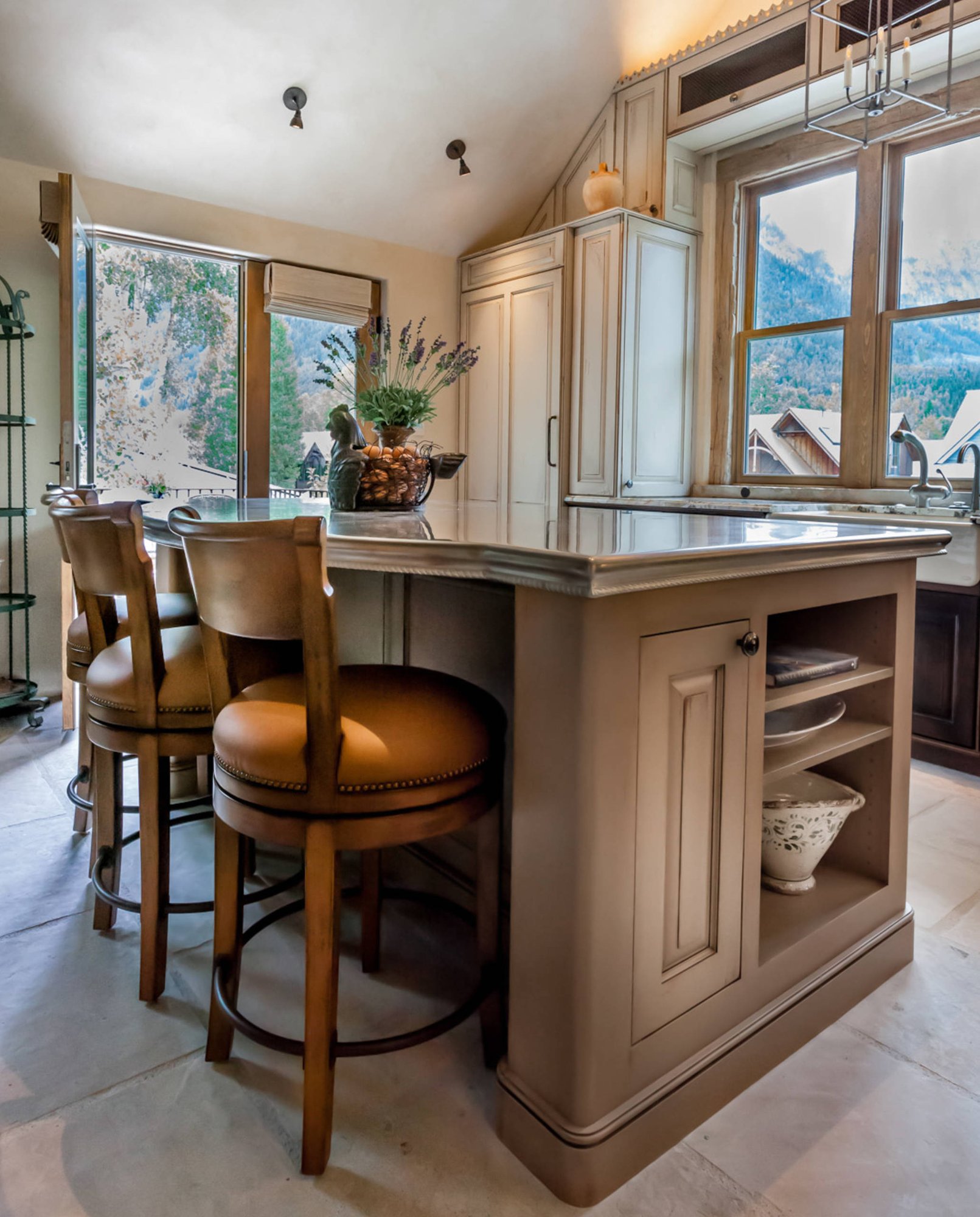 Mid-sized classic l-shaped ceramic tile open concept kitchen with a farmhouse sink, raised-panel cabinets, paneled appliances, an island, dark wood cabinets and granite countertops, by Jensen Design in Telluride, CO