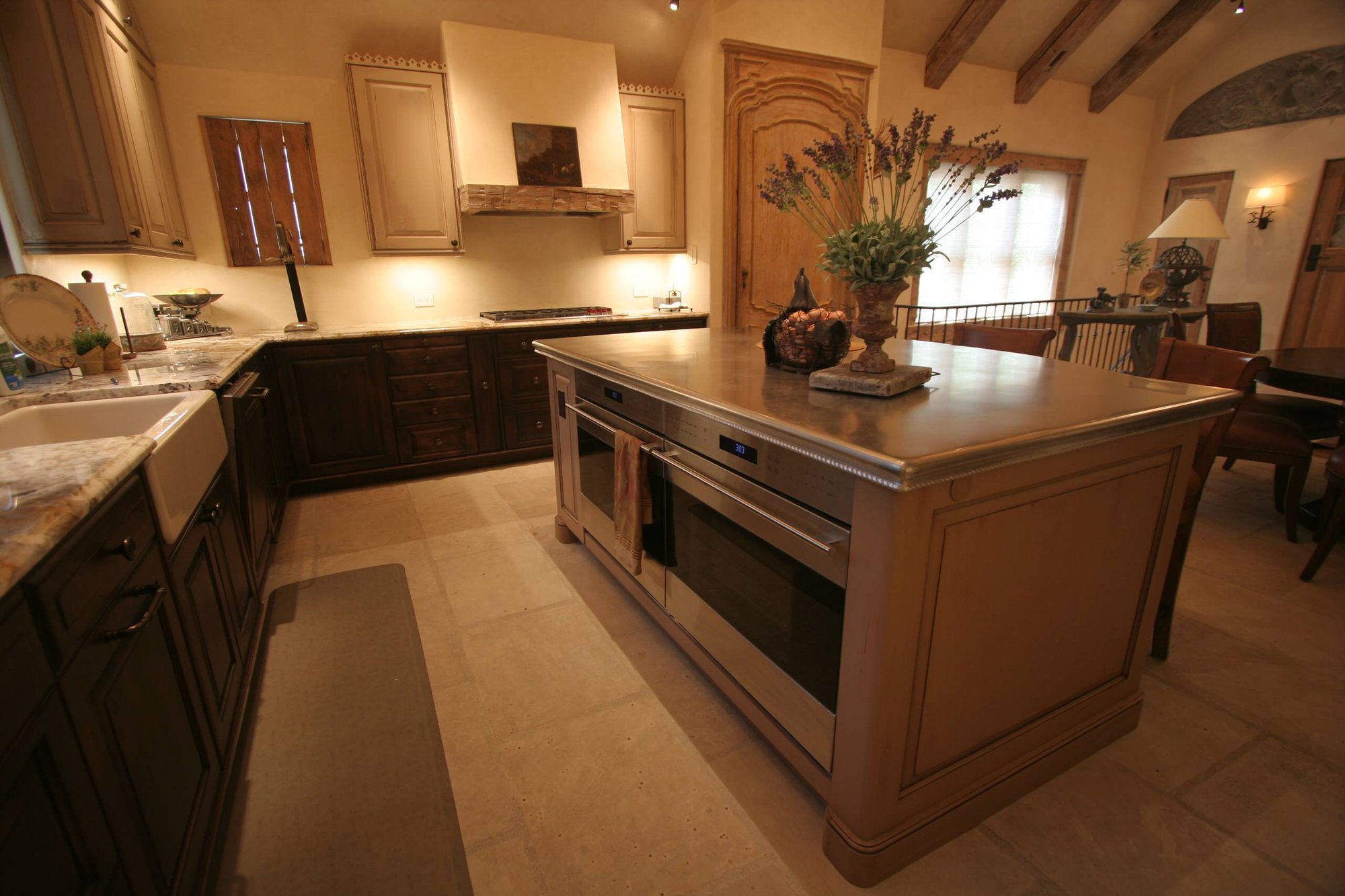 Mid-sized elegant l-shaped ceramic tile open concept kitchen with a farmhouse sink, raised-panel cabinets, paneled appliances, an island, black cabinets and granite countertops, by Jensen Design in Telluride, CO