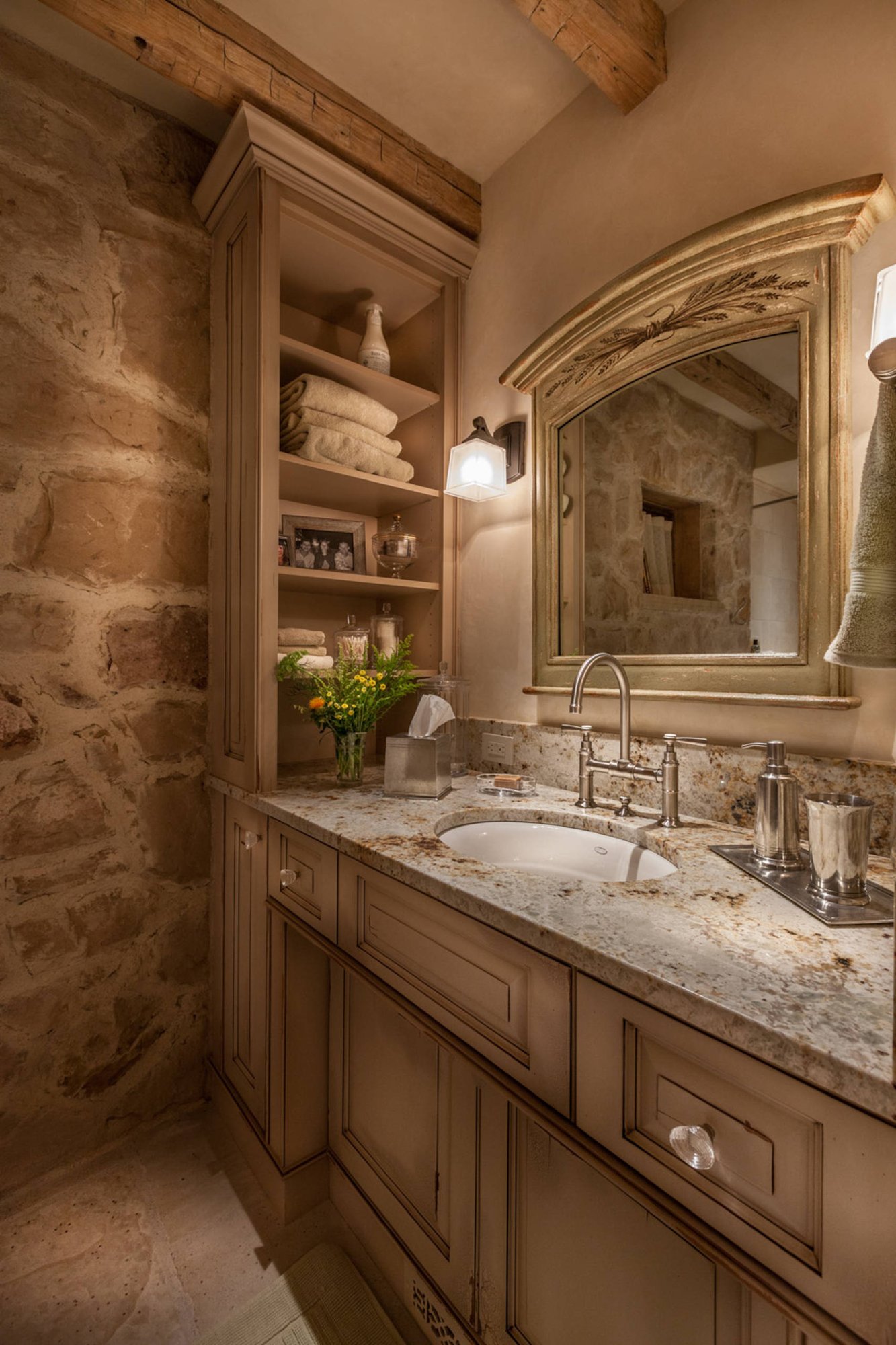 Mid-sized traditional 3/4 beige tile porcelain tile bathroom with raised-panel cabinets, an undermount sink, distressed cabinets, beige walls and granite countertops, by Jensen Design in Telluride, CO