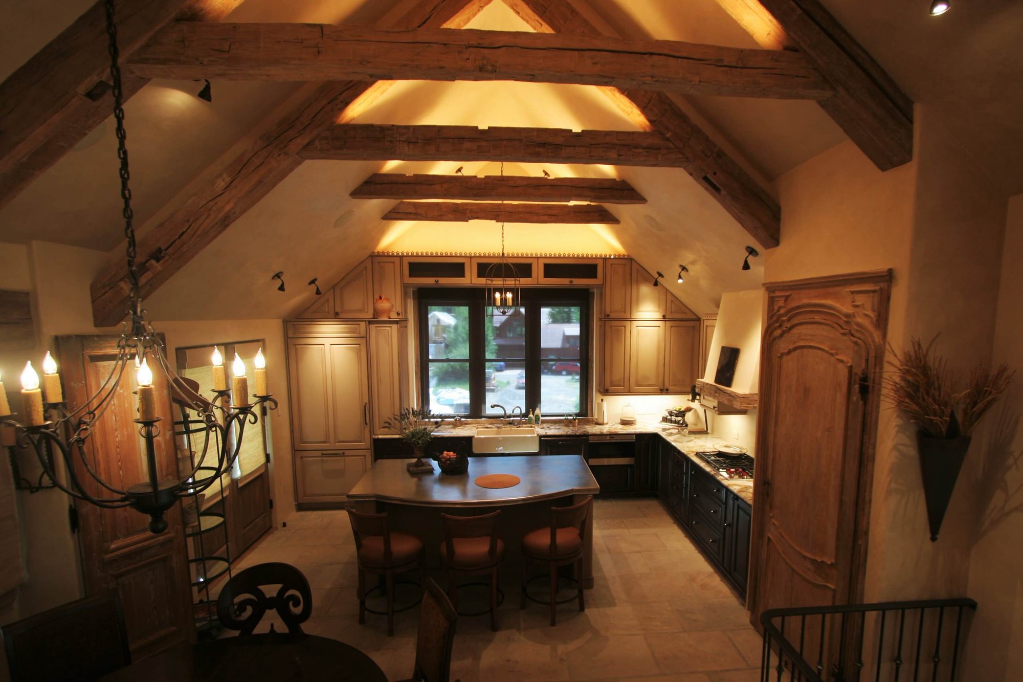 Mid-sized classic l-shaped ceramic tile open concept kitchen with a farmhouse sink, raised-panel cabinets, paneled appliances, an island, black cabinets and soapstone countertops, by Jensen Design in Telluride, CO