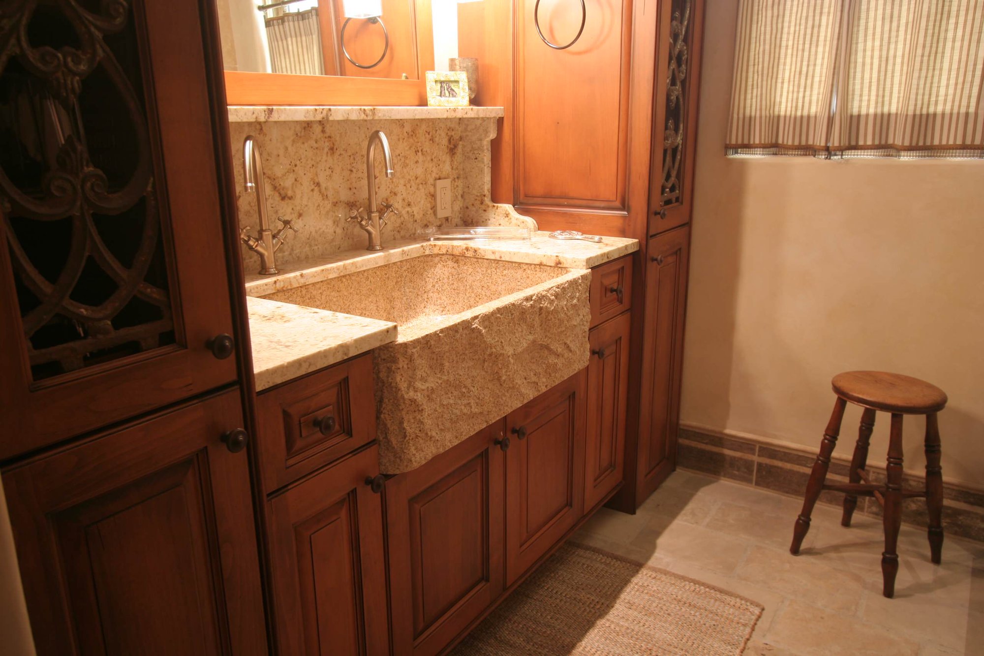 Mid-sized craftsman master beige tile slate floor bathroom with raised-panel cabinets, medium tone wood cabinets, beige walls, an integrated sink, granite countertops and a one-piece toilet, by Jensen Design in Telluride, CO