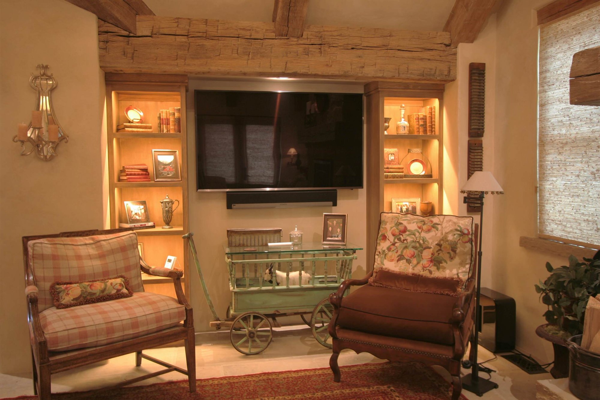 Small traditional open concept and formal living room with beige walls and a wall-mounted tv, by Jensen Design in Telluride, CO