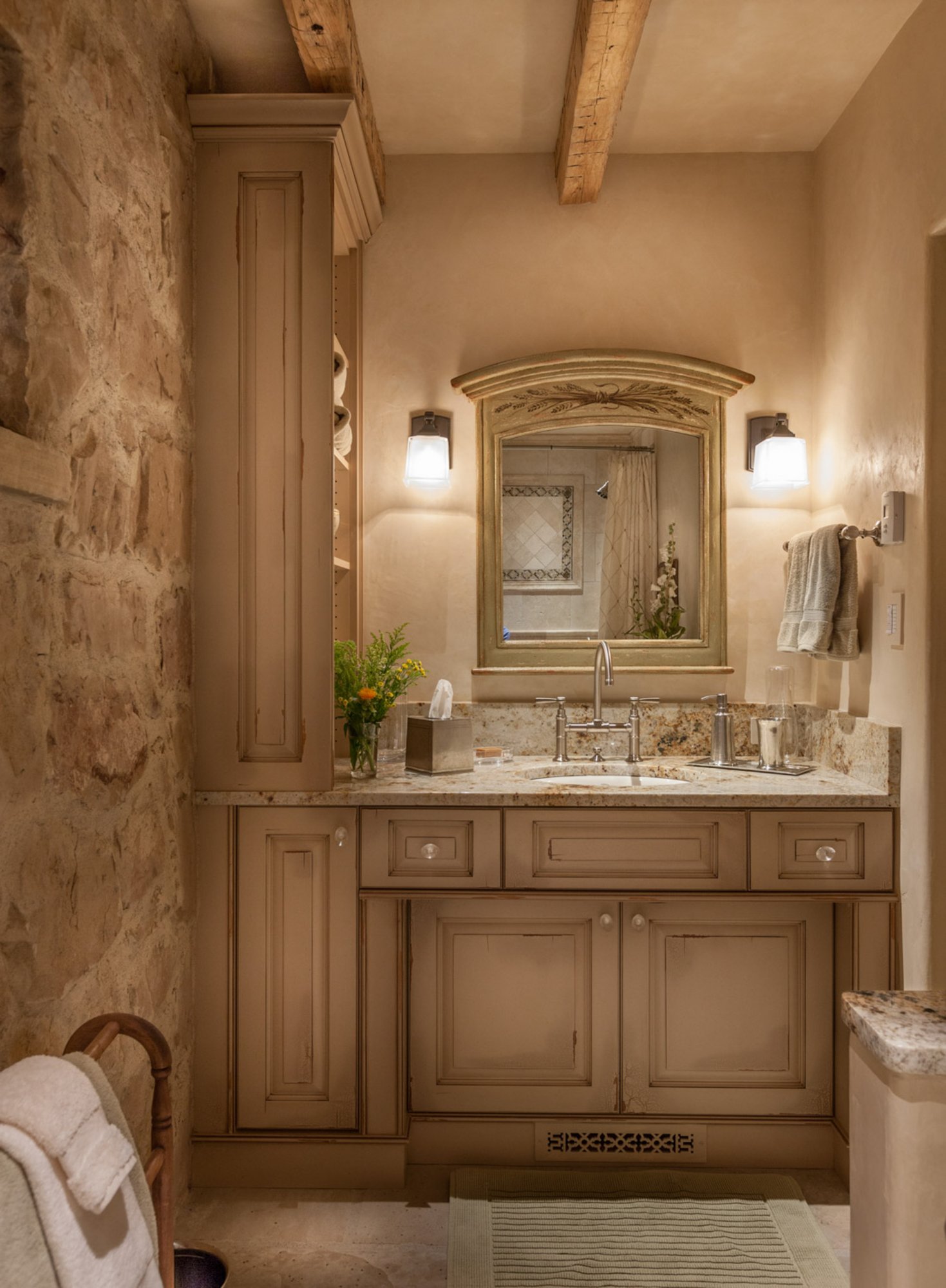 Mid-sized elegant 3/4 beige tile porcelain tile bathroom with raised-panel cabinets, an undermount sink, distressed cabinets, beige walls and granite countertops, by Jensen Design in Telluride, CO