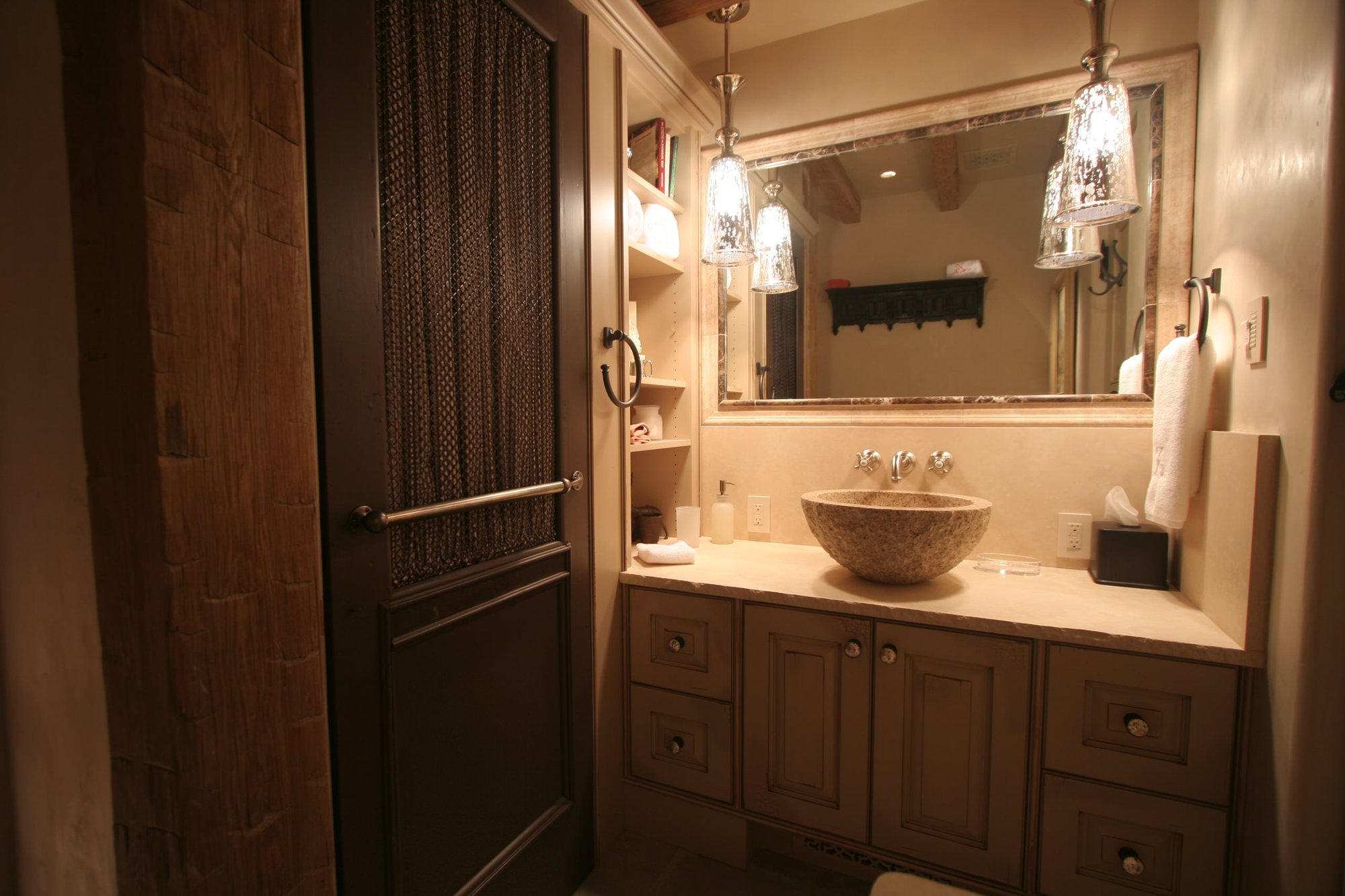 Mid-sized elegant 3/4 beige tile bathroom with raised-panel cabinets, beige walls, a vessel sink, distressed cabinets and soapstone countertops, by Jensen Design in Telluride, CO