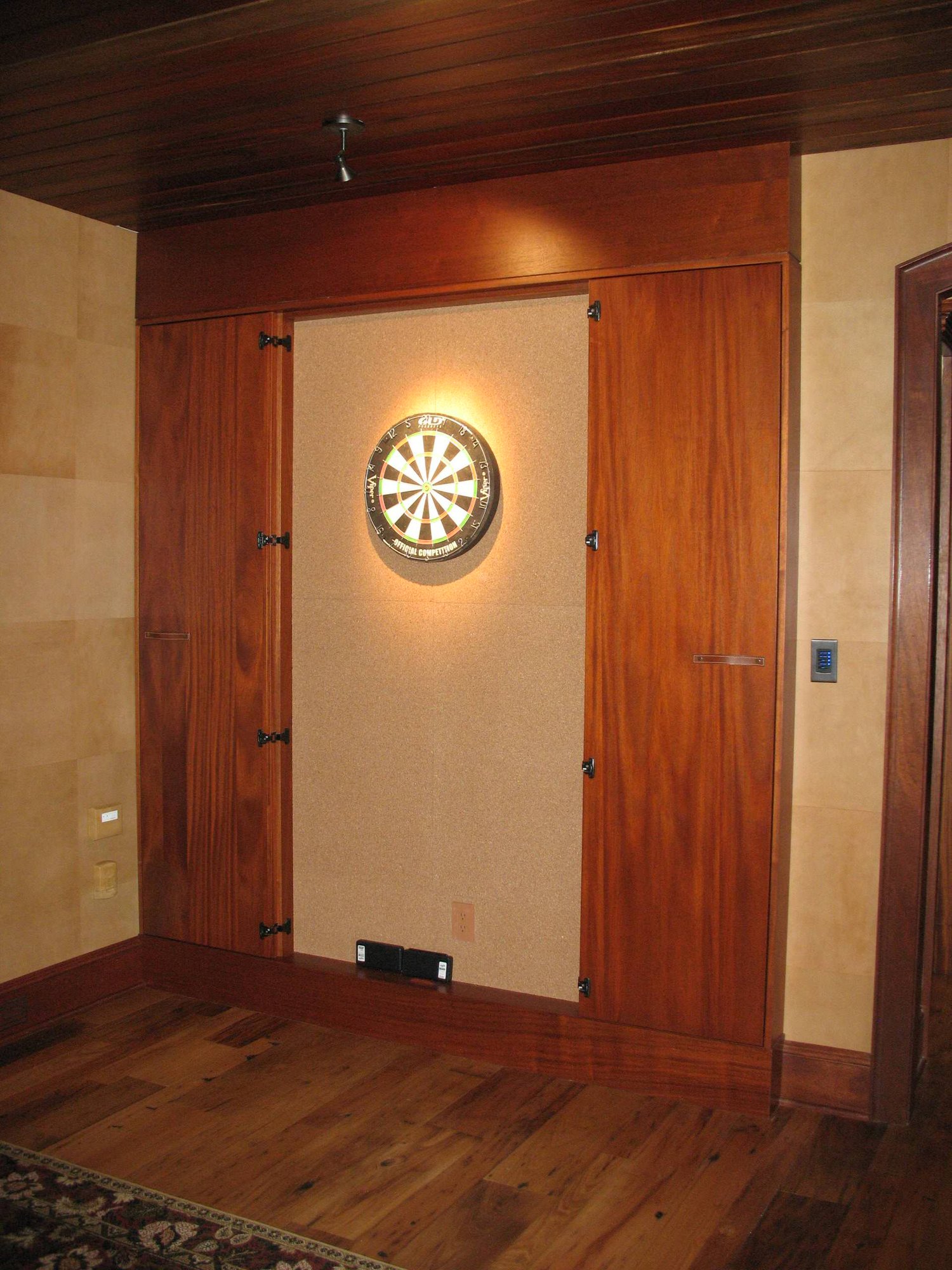 Mid-sized traditional open concept dark wood floor and brown floor game room with beige walls, a standard fireplace and a concrete fireplace, by Jensen Design in Telluride, CO