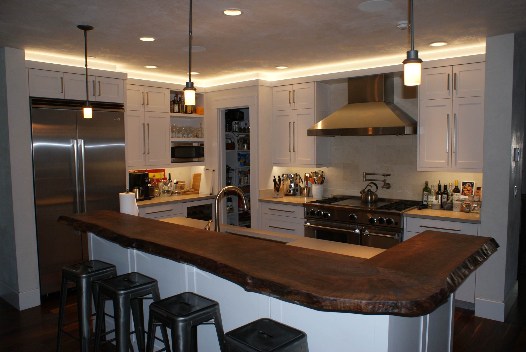 Mid-sized arts and crafts l-shaped dark wood floor open concept kitchen with an undermount sink, shaker cabinets, white cabinets, stainless steel appliances, an island, beige backsplash and stone tile backsplash, by Jensen Design in Telluride, CO