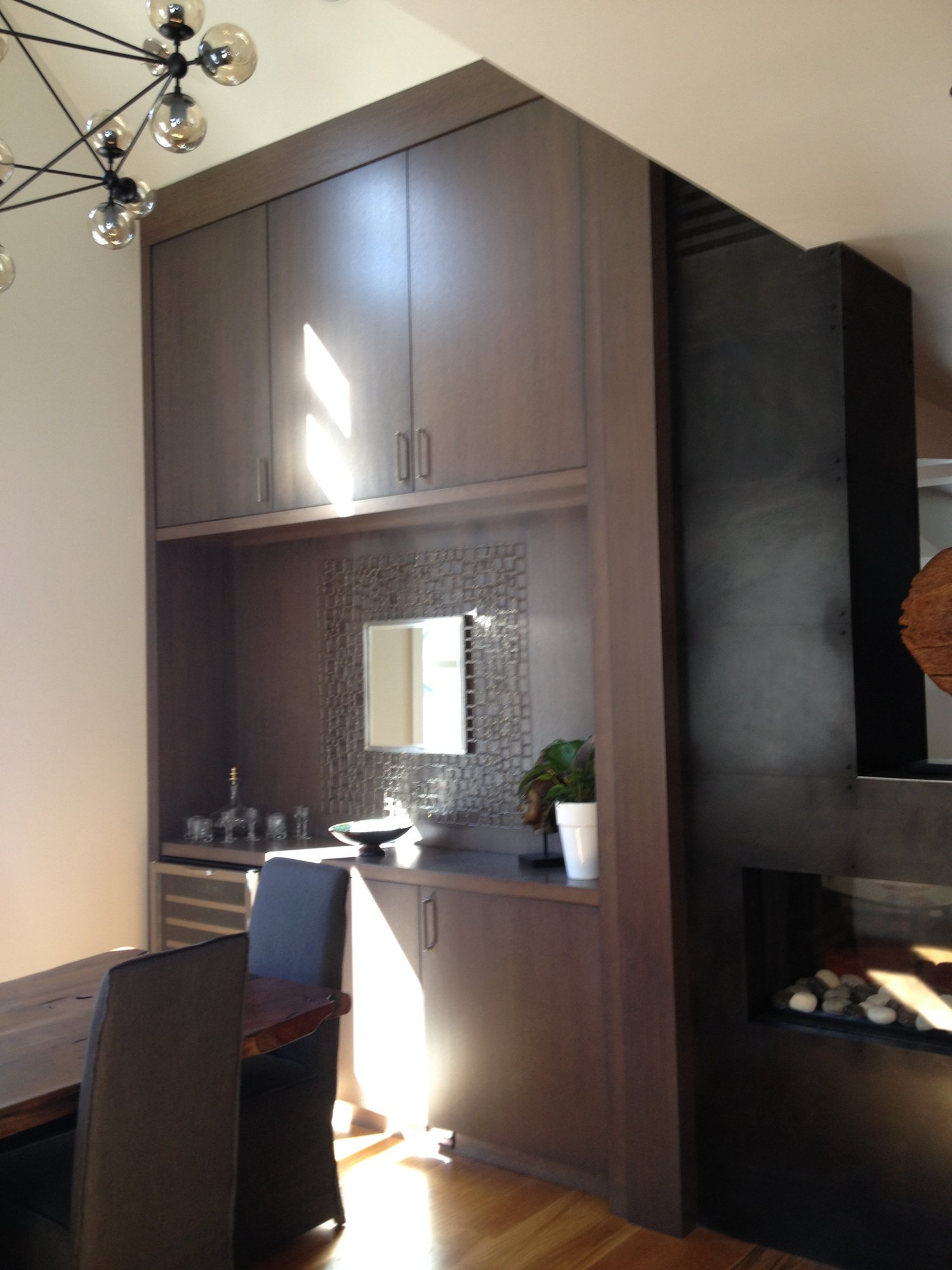Mid-sized trendy l-shaped dark wood floor open concept kitchen with an undermount sink, flat-panel cabinets, dark wood cabinets, quartzite countertops, white backsplash, stone slab backsplash, stainless steel appliances and an island, by Jensen Design in Telluride, CO
