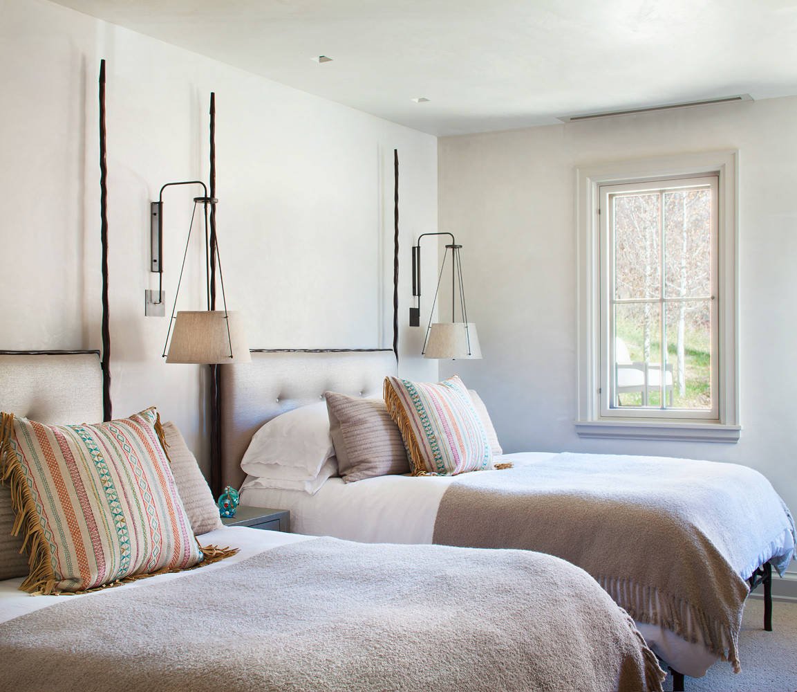 Rustic carpeted bedroom with white walls, by Jensen Design in Telluride, CO