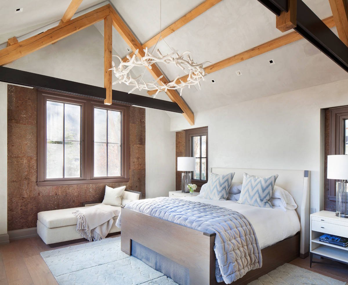 Mountain style medium tone wood floor bedroom with white walls, by Jensen Design in Telluride, CO