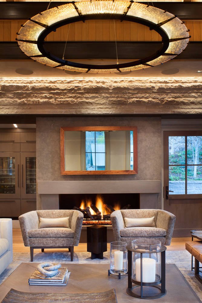 Mountain style medium tone wood floor living room with gray walls and a standard fireplace, by Jensen Design in Telluride, CO