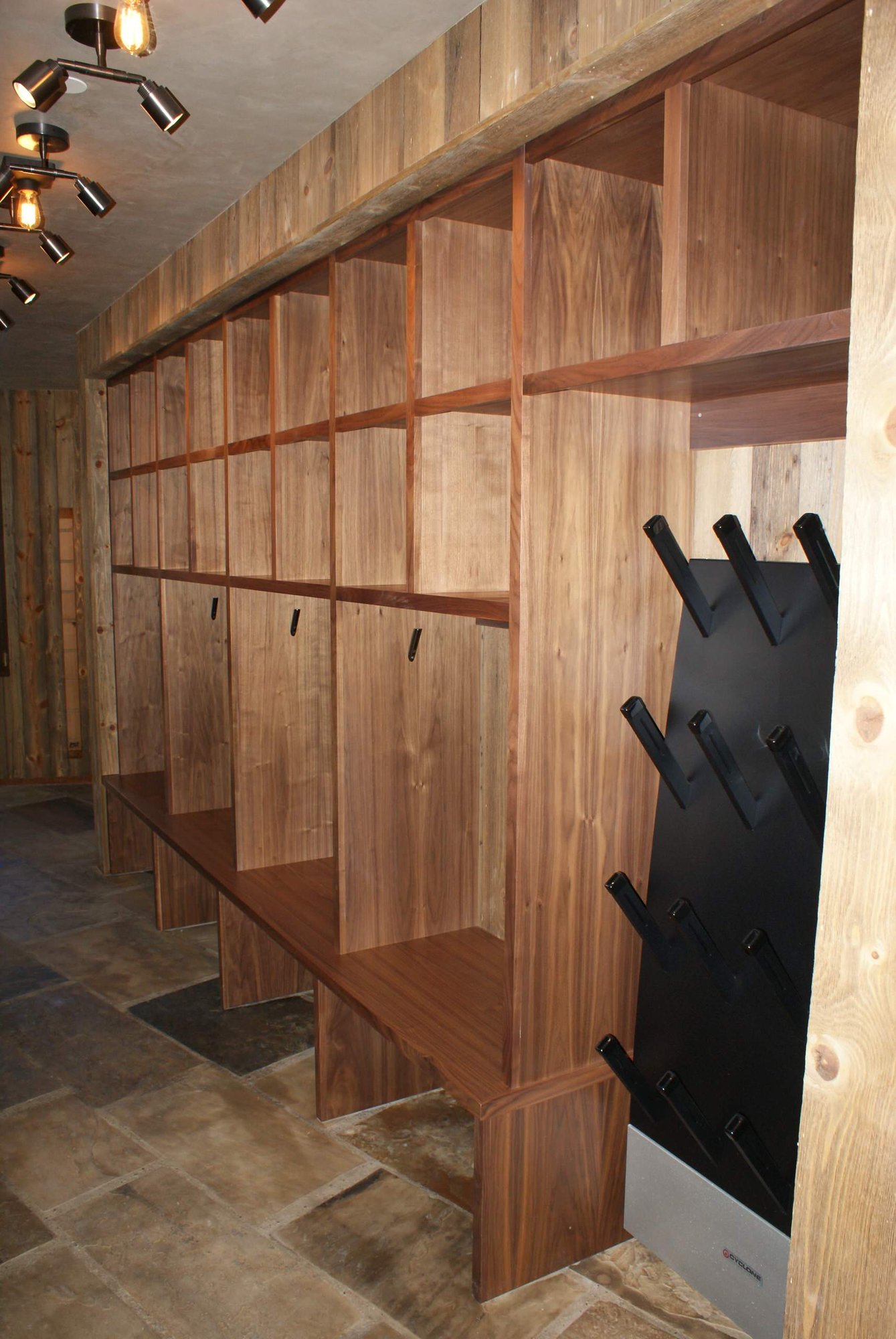 Large timeless gender-neutral dressing room with medium tone wood cabinets and open cabinets, by Jensen Design in Telluride, CO