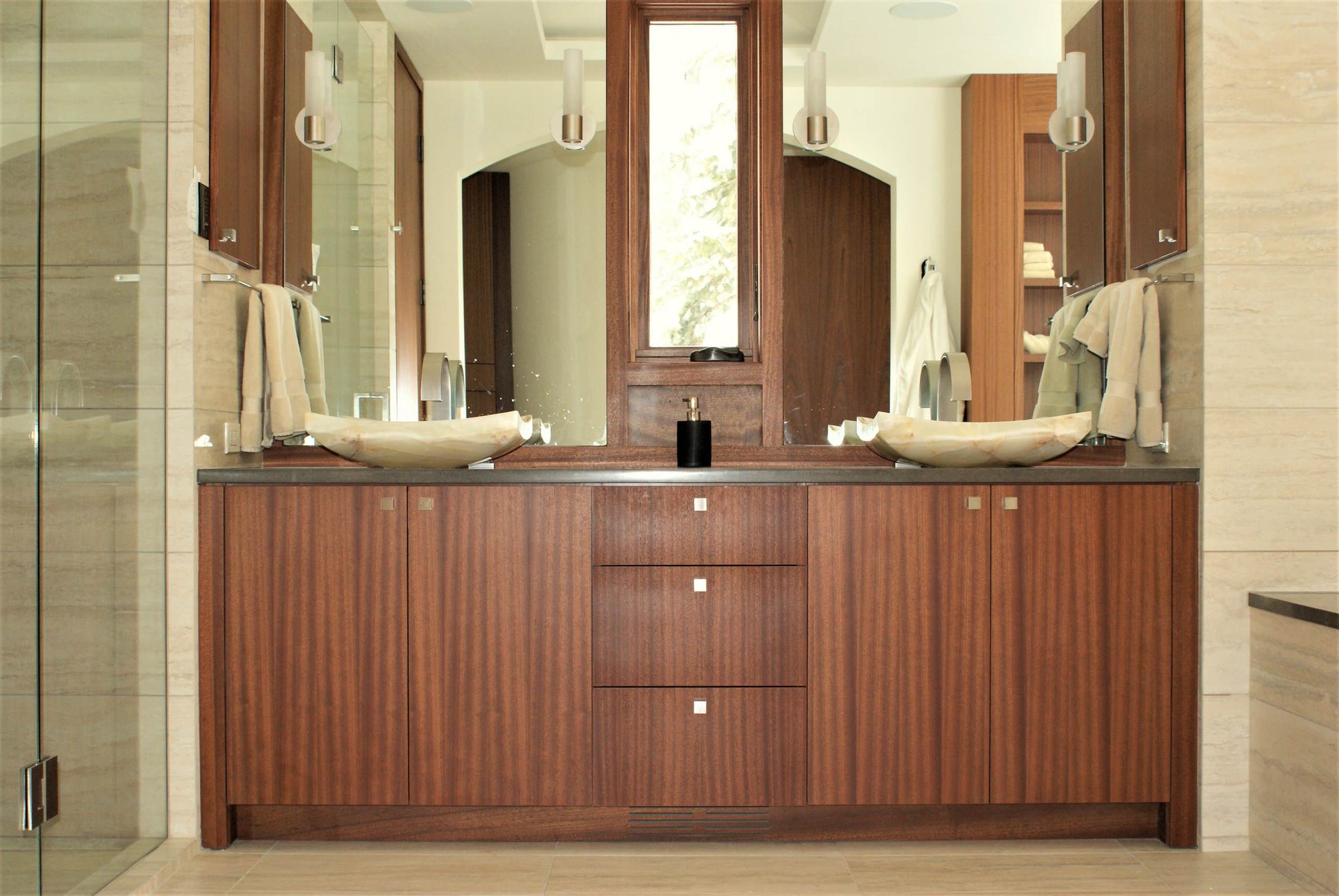 Mid-sized contemporary master porcelain tile alcove shower with flat-panel cabinets, medium tone wood cabinets, a vessel sink, beige walls, solid surface countertops and an undermount tub, by Jensen Design in Telluride, CO