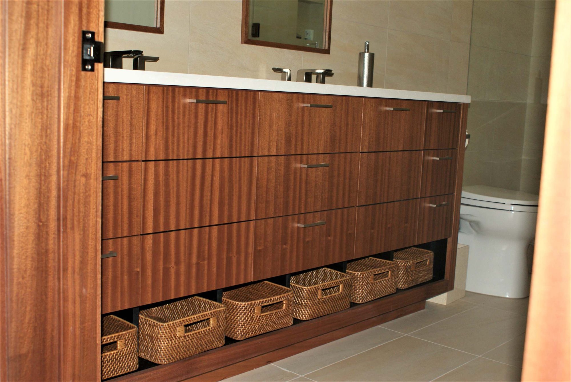 Mid-sized contemporary 3/4 beige tile and ceramic tile porcelain tile alcove shower with flat-panel cabinets, medium tone wood cabinets, an undermount sink, a one-piece toilet, beige walls and solid surface countertops, by Jensen Design in Telluride, CO