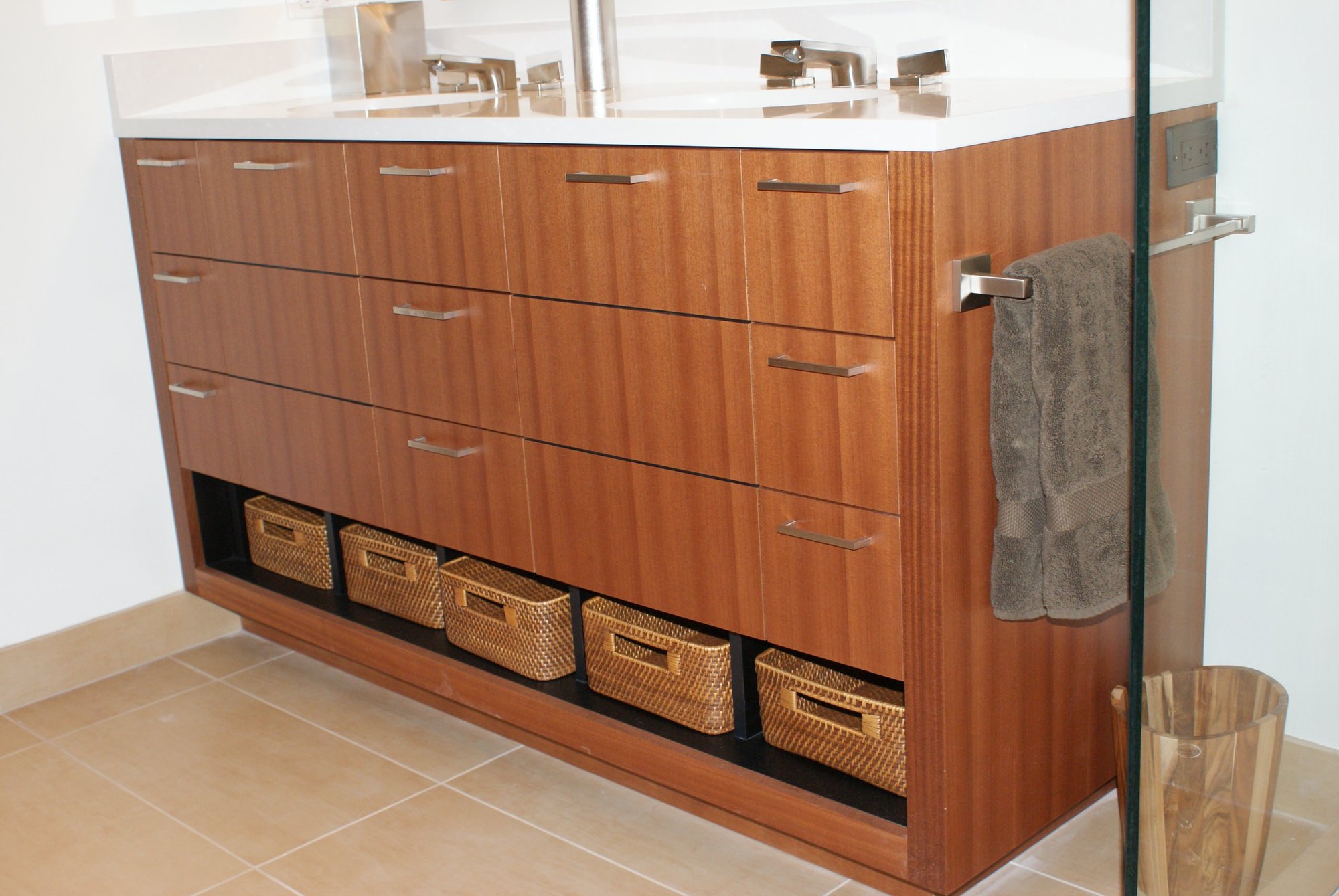 Mid-sized trendy 3/4 beige tile and ceramic tile porcelain tile bathroom with flat-panel cabinets, medium tone wood cabinets, an undermount sink, a one-piece toilet, white walls and solid surface countertops, by Jensen Design in Telluride, CO