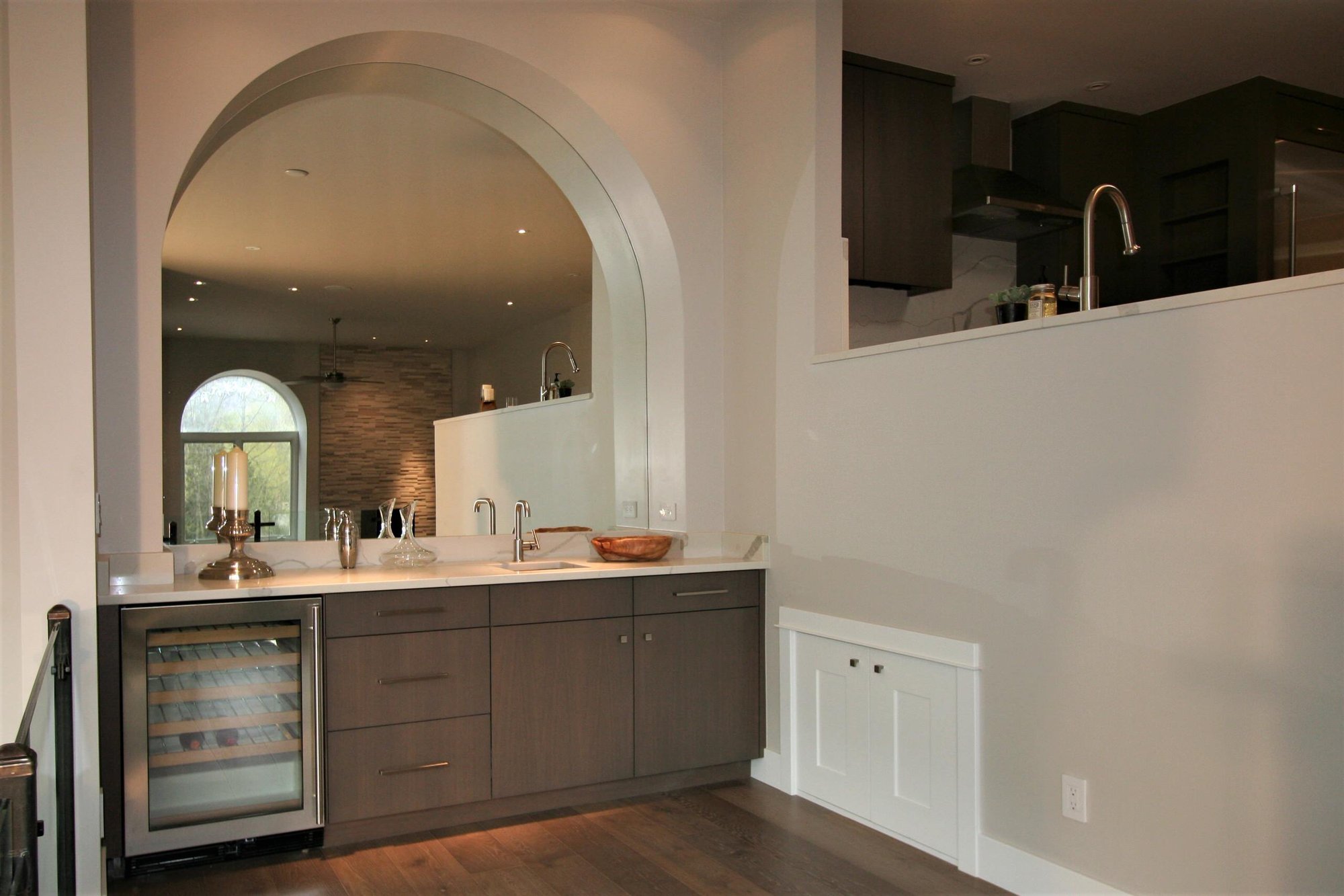 Small contemporary galley medium tone wood floor wet bar with an undermount sink, flat-panel cabinets and medium tone wood cabinets, by Jensen Design in Telluride, CO