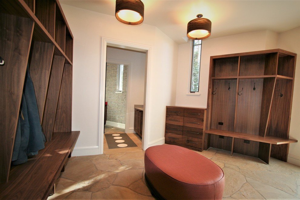 Large rustic beige floor entryway with a white front door and beige walls, by Jensen Design in Mountain Village, CO