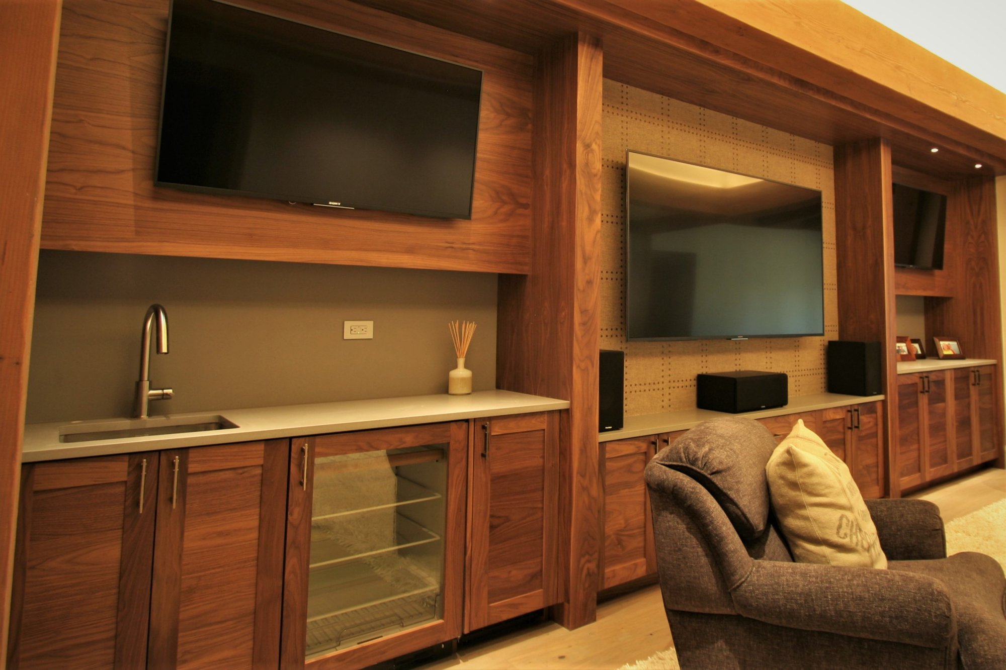 Large trendy open concept light wood floor and brown floor home theater with a wall-mounted tv and blue walls, by Jensen Design in Mountain Village, CO