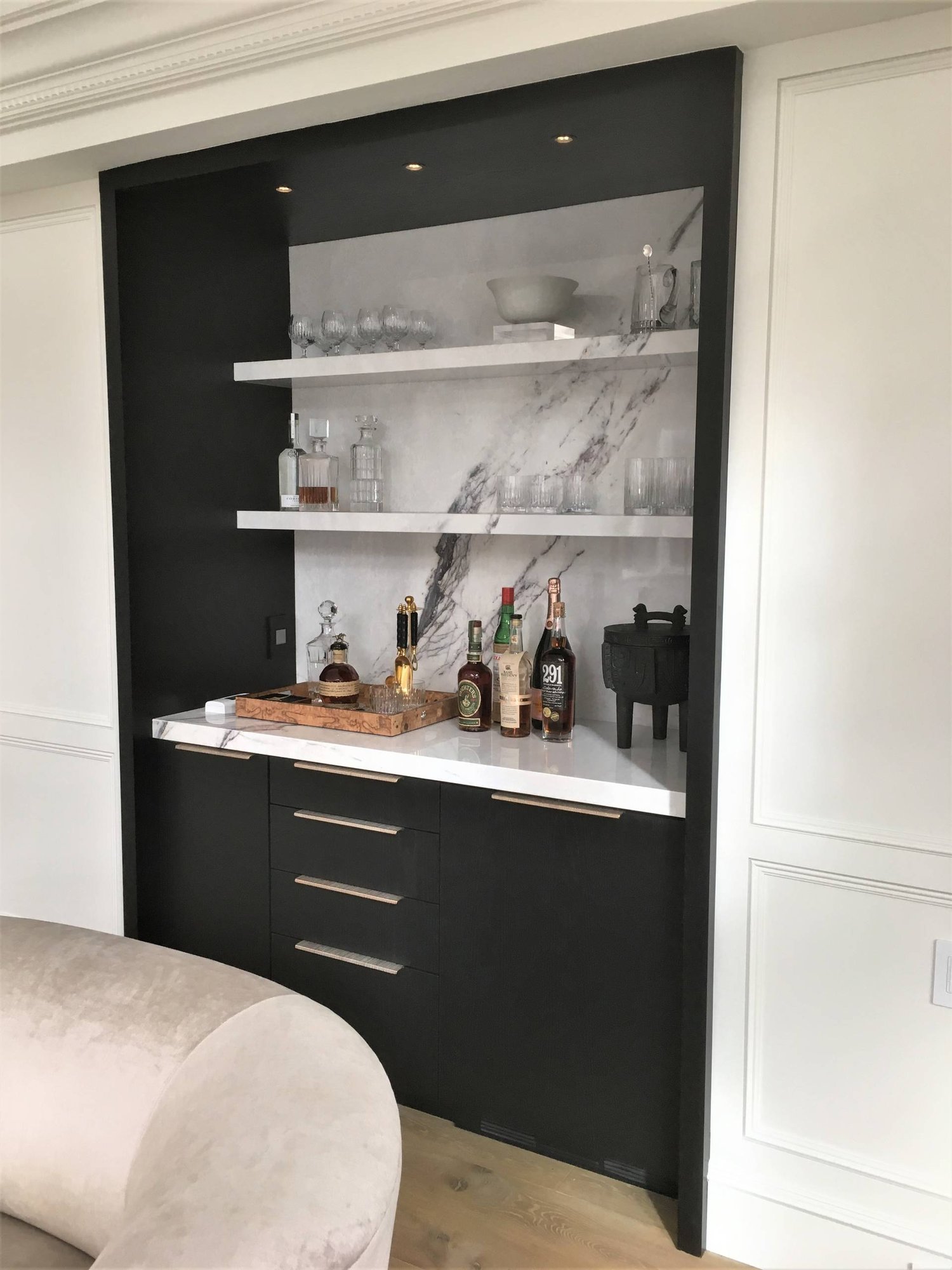 Mid-sized minimalist galley light wood floor home bar with no sink, flat-panel cabinets, black cabinets, marble countertops, white backsplash and marble backsplash, by Jensen Design in Telluride, CO