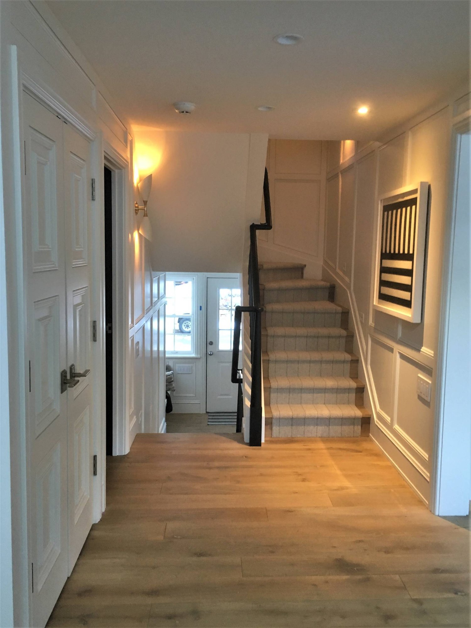 Mid-sized minimalist light wood floor entryway with white walls and a white front door, by Jensen Design in Telluride, CO