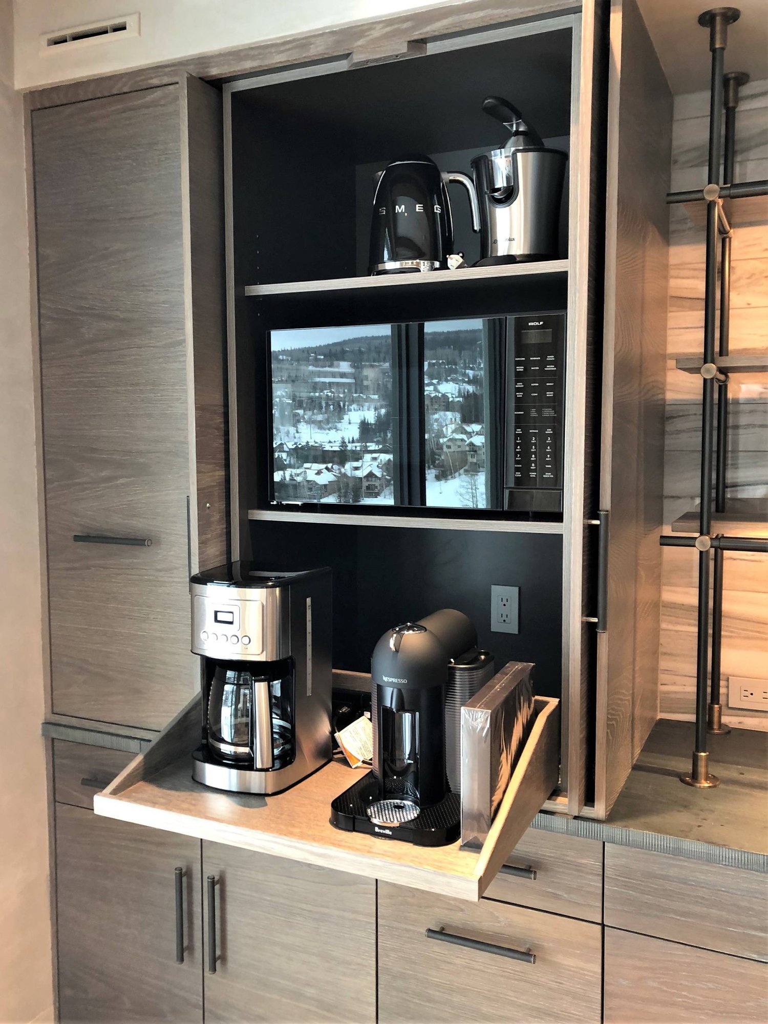 Large trendy u-shaped medium tone wood floor and brown floor eat-in kitchen with a farmhouse sink, flat-panel cabinets, light wood cabinets, stainless steel appliances, an island, concrete countertops, gray backsplash, marble backsplash and gray countertops, by Jensen Design in Mountain Village, CO