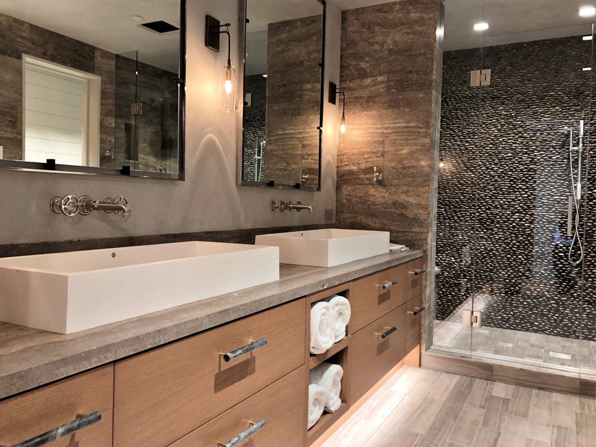 Large contemporary master stone tile porcelain tile and gray floor alcove shower with flat-panel cabinets, medium tone wood cabinets, a two-piece toilet, multicolored walls, a vessel sink, concrete countertops, a hinged shower door and gray countertops, by Jensen Design in Mountain Village, CO