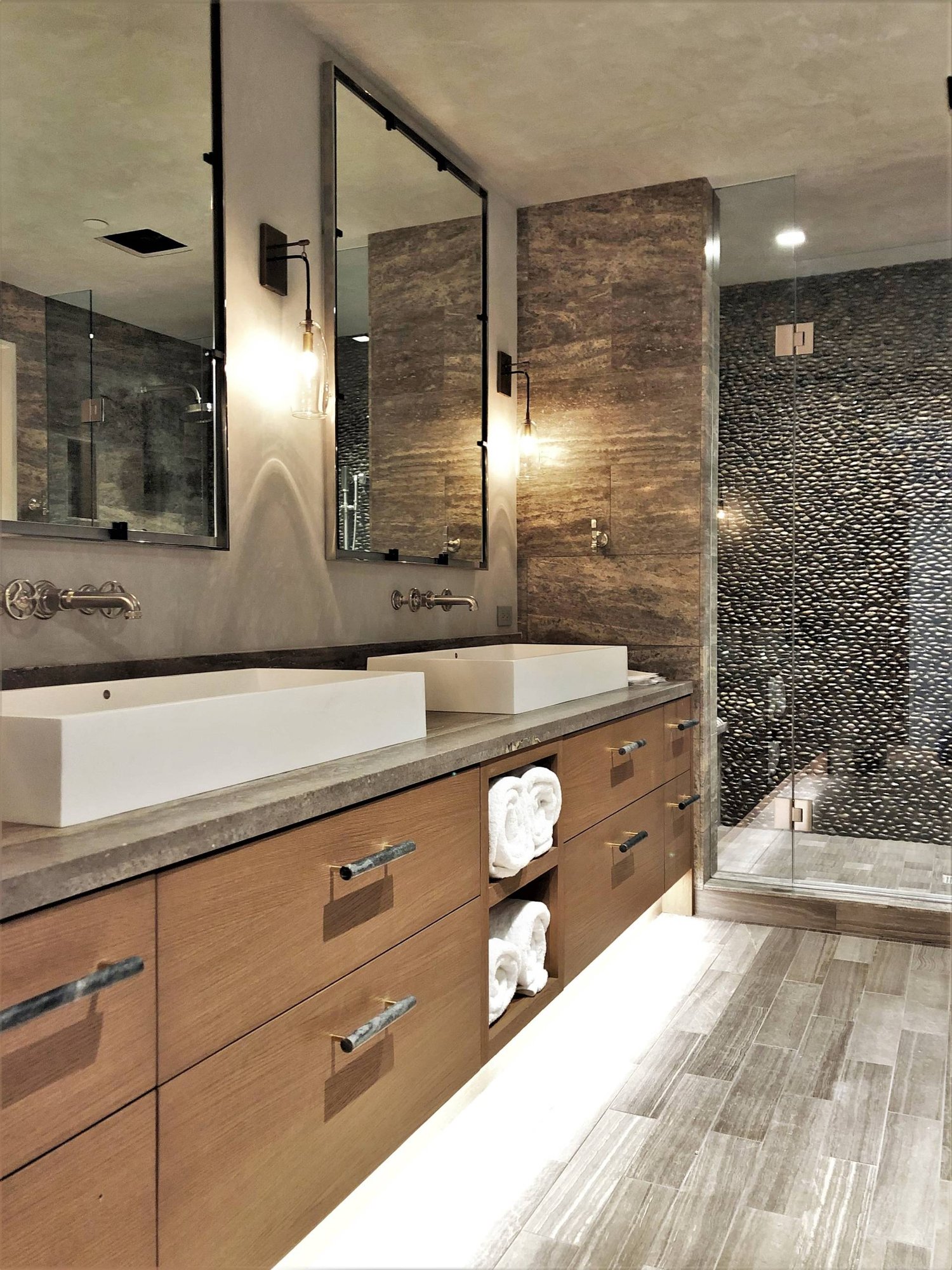 Large contemporary master stone tile porcelain tile and gray floor alcove shower with flat-panel cabinets, medium tone wood cabinets, a two-piece toilet, multicolored walls, a vessel sink, concrete countertops, a hinged shower door and gray countertops, by Jensen Design in Mountain Village, CO