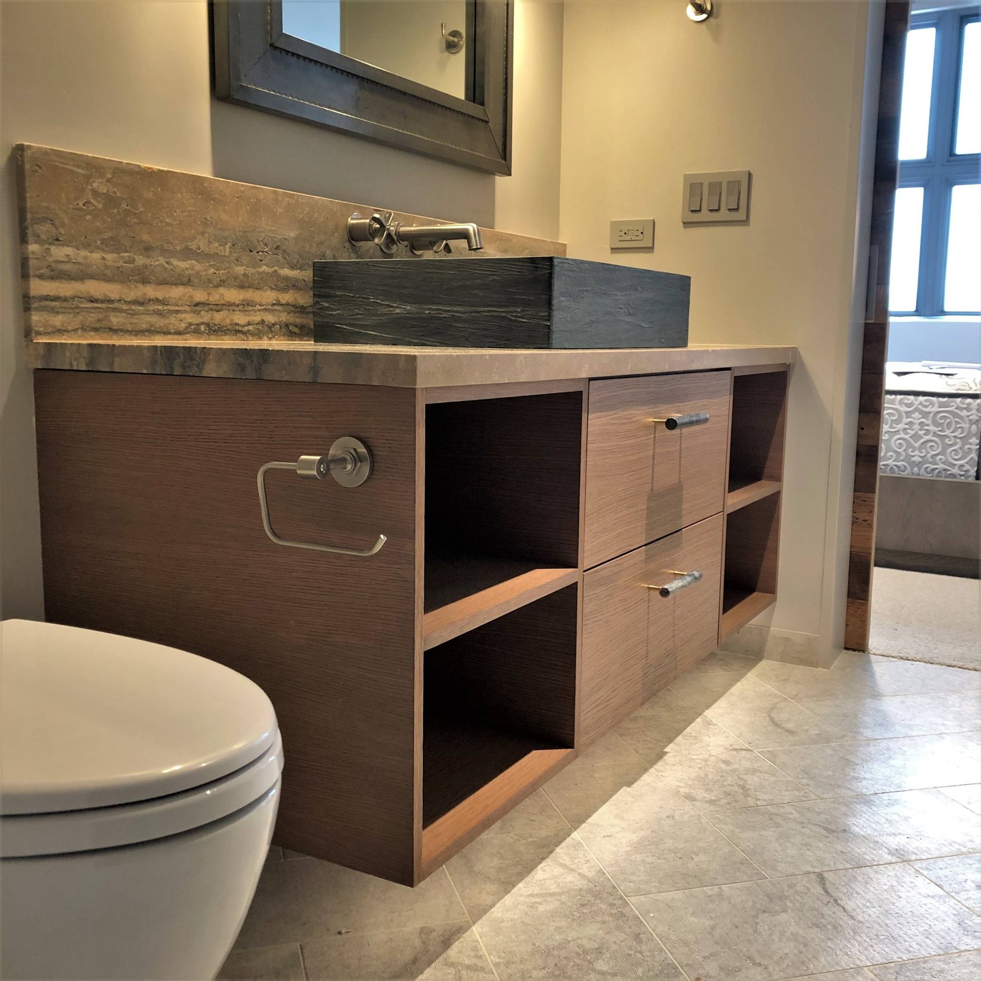 Mid-sized contemporary stone slab gray floor and marble floor powder room with flat-panel cabinets, medium tone wood cabinets, a two-piece toilet, a vessel sink, multicolored countertops and beige walls, by Jensen Design in Mountain Village, CO