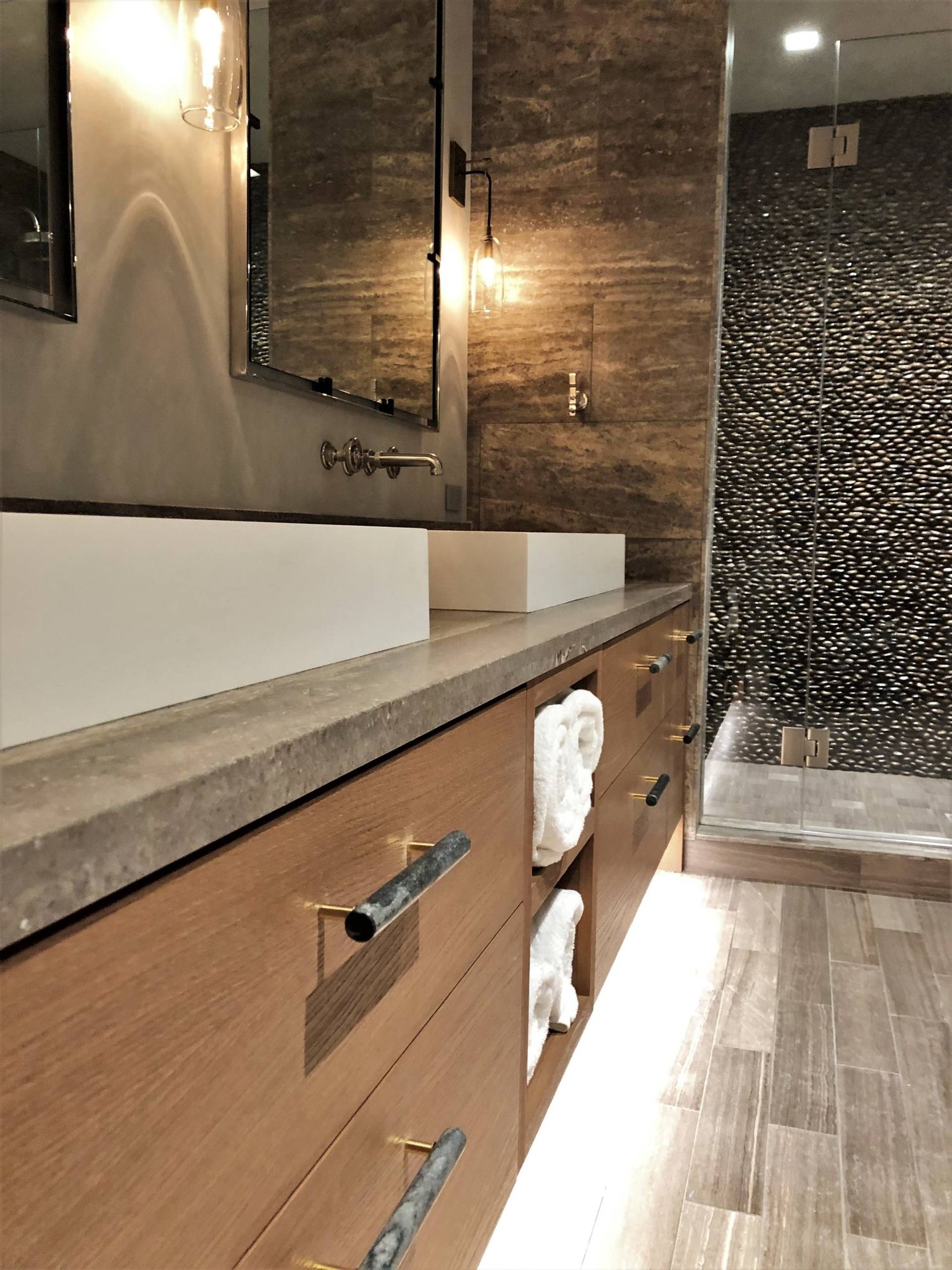 Large contemporary master stone tile porcelain tile and gray floor alcove shower with flat-panel cabinets, medium tone wood cabinets, a two-piece toilet, multicolored walls, a vessel sink, concrete countertops, a hinged shower door and gray countertops, by Jensen Design in Mountain Village, CO