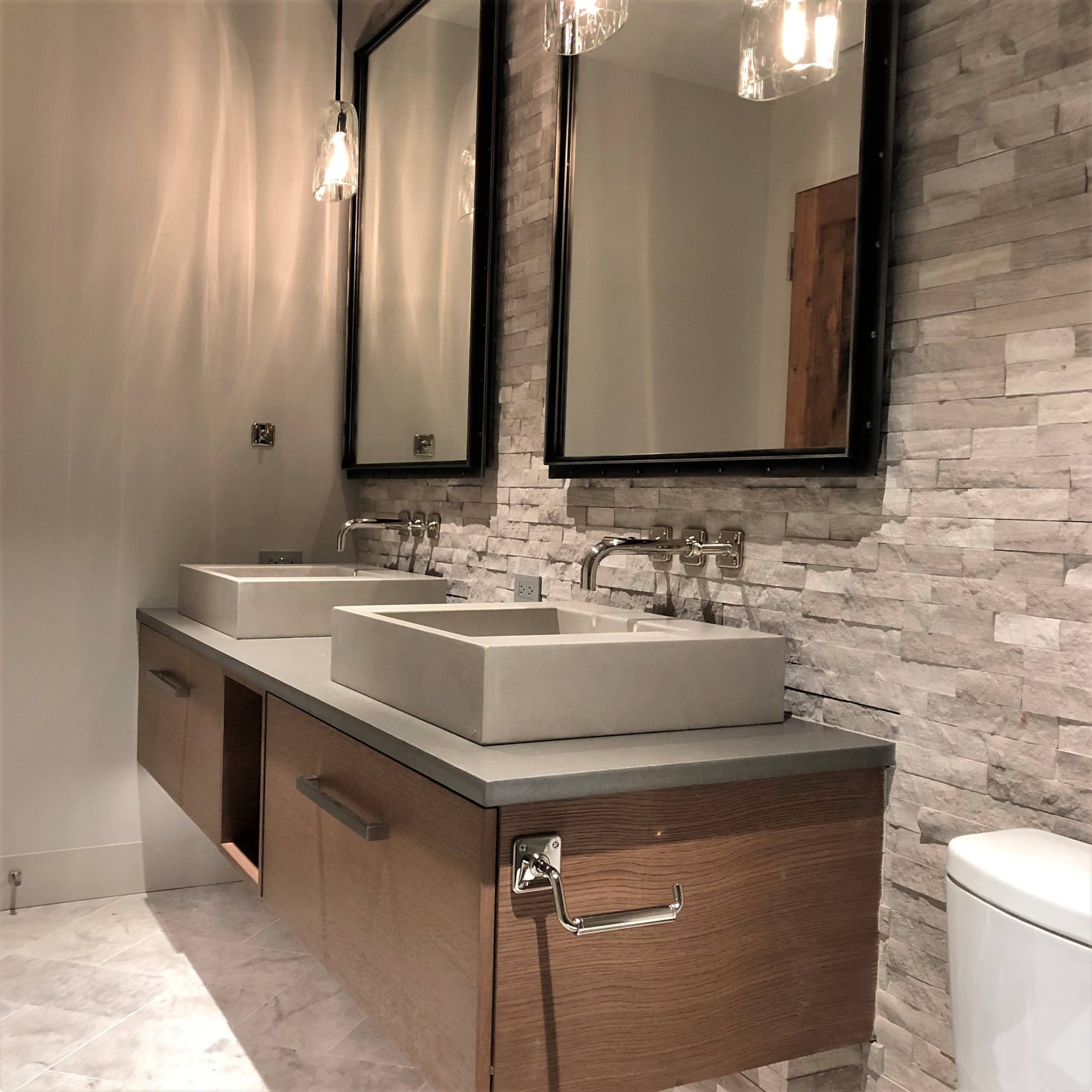 Mid-sized trendy gray tile and stone tile marble floor and gray floor alcove shower with flat-panel cabinets, medium tone wood cabinets, a two-piece toilet, gray walls, a vessel sink, quartzite countertops and gray countertops, by Jensen Design in Mountain Village, CO