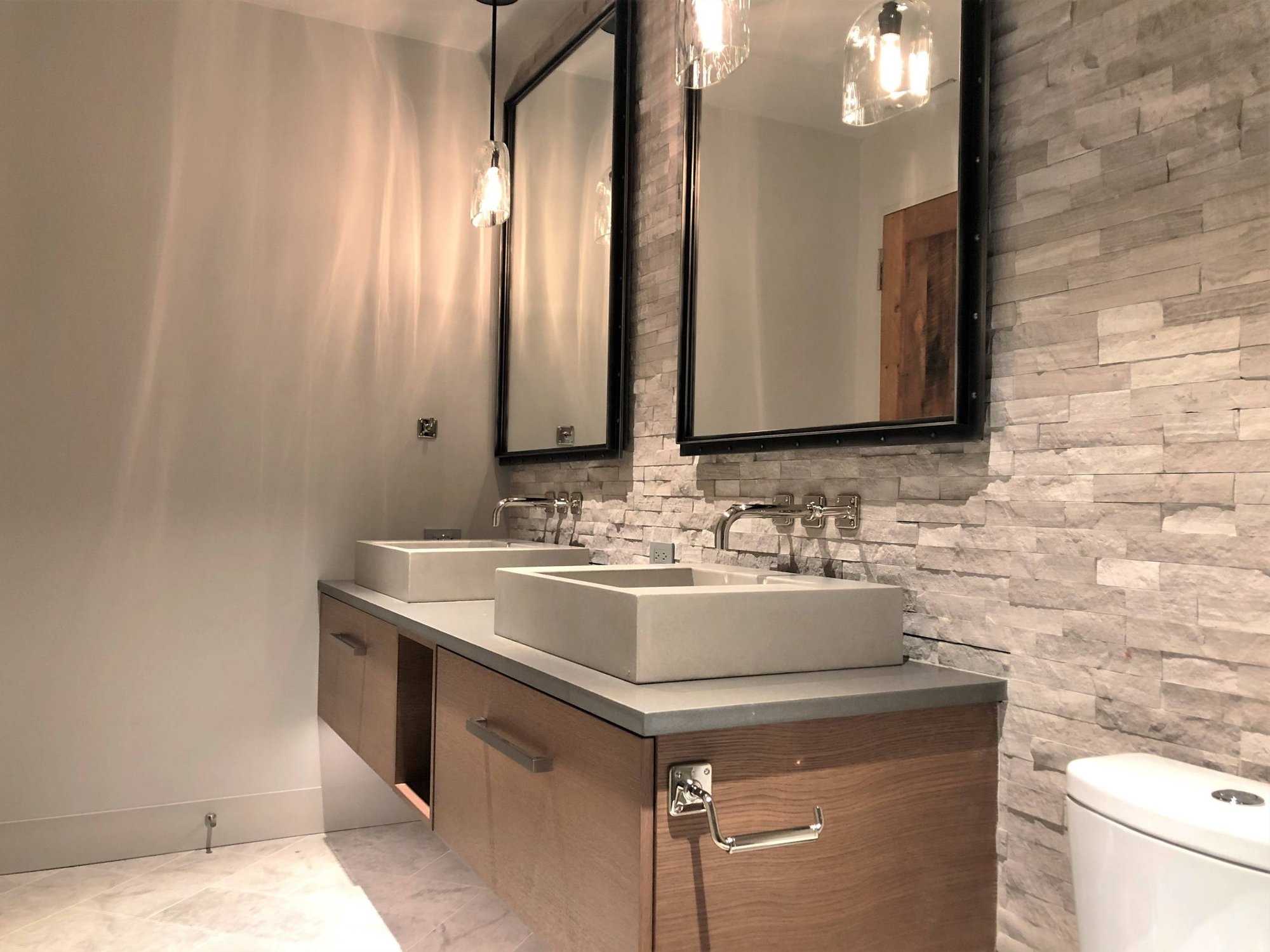 Mid-sized trendy gray tile and stone tile marble floor and gray floor alcove shower with flat-panel cabinets, medium tone wood cabinets, a two-piece toilet, gray walls, a vessel sink, quartzite countertops and gray countertops, by Jensen Design in Mountain Village, CO
