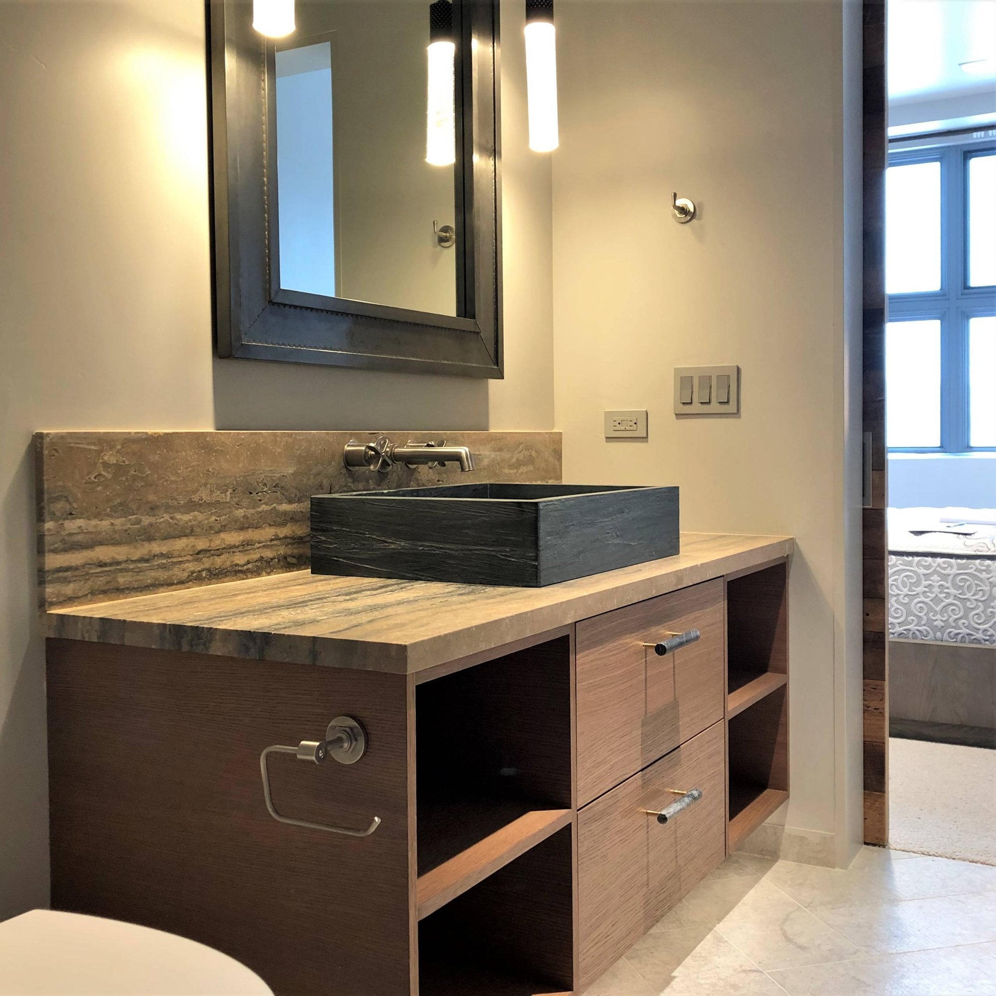 Mid-sized contemporary stone slab marble floor and gray floor powder room with flat-panel cabinets, medium tone wood cabinets, a two-piece toilet, a vessel sink, multicolored countertops and beige walls, by Jensen Design in Mountain Village, CO