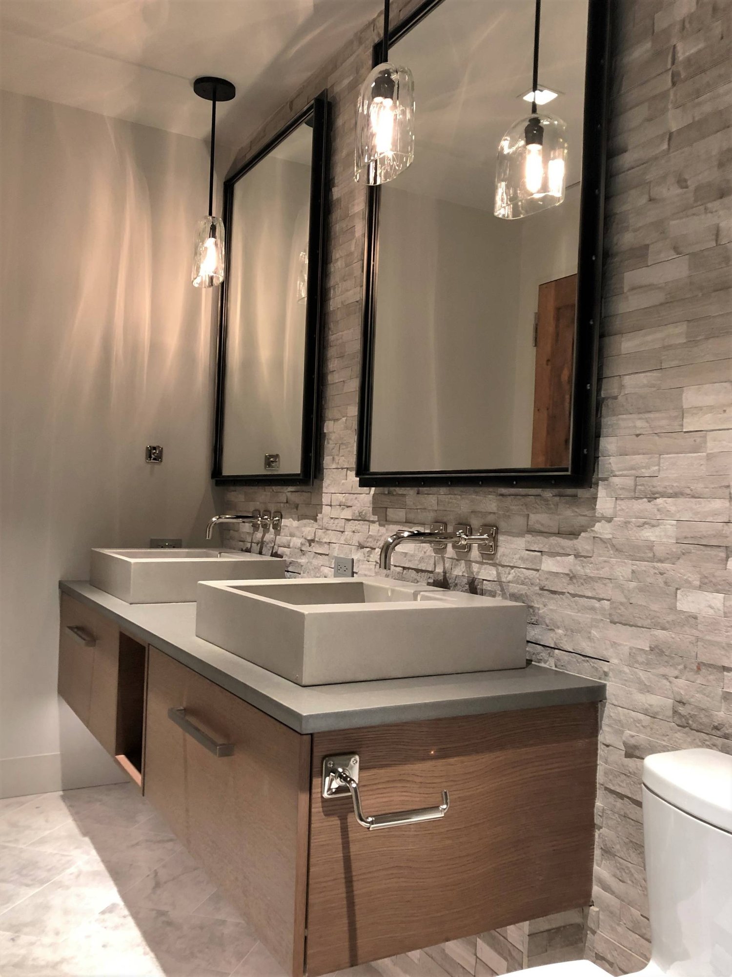 Mid-sized trendy gray tile and stone tile marble floor and gray floor alcove shower with flat-panel cabinets, medium tone wood cabinets, a two-piece toilet, gray walls, a vessel sink, quartzite countertops and gray countertops, by Jensen Design in Mountain Village, CO