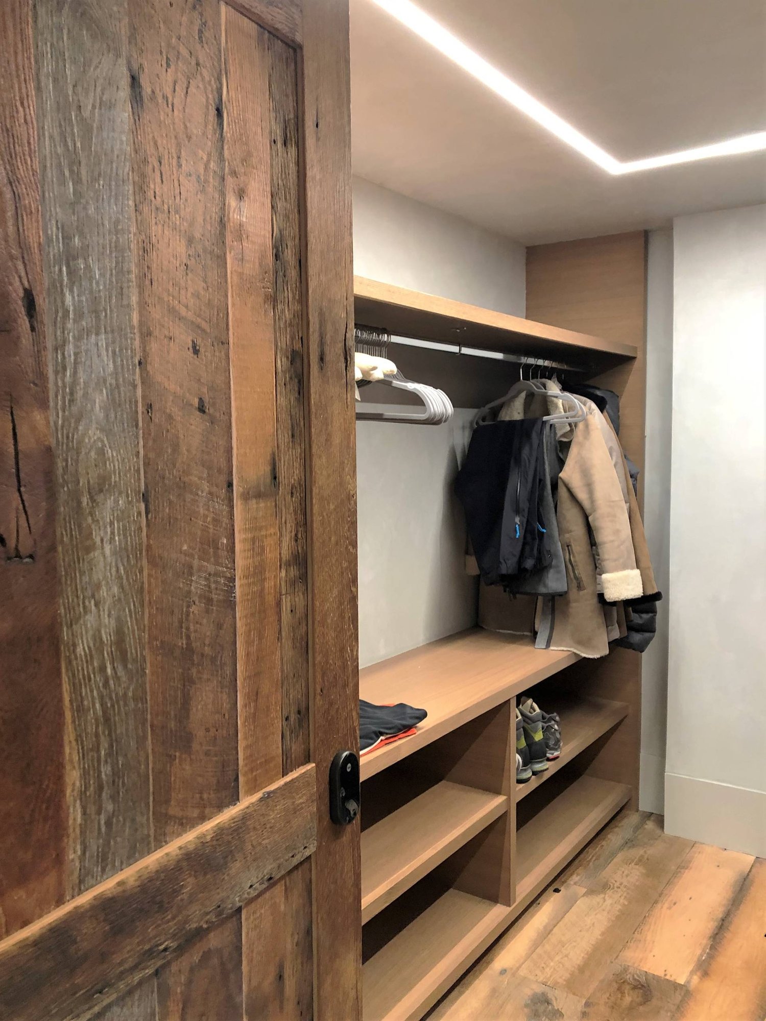 Mid-sized trendy gender-neutral light wood floor and brown floor walk-in closet with open cabinets and light wood cabinets, by Jensen Design in Mountain Village, CO