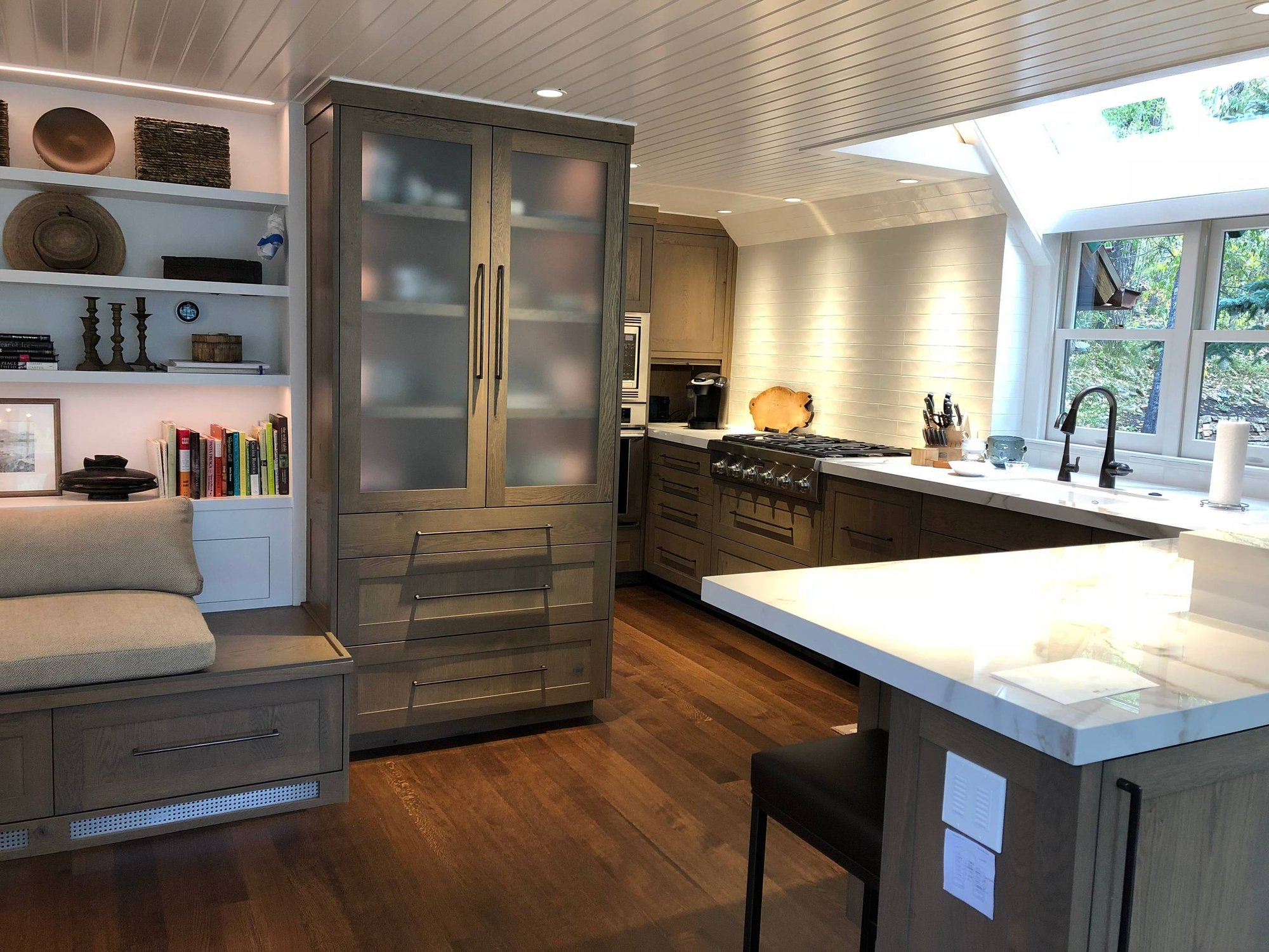 Mid-sized contemporary l-shaped dark wood floor and brown floor eat-in kitchen with an undermount sink, flat-panel cabinets, gray cabinets, quartzite countertops, white backsplash, subway tile backsplash, stainless steel appliances, a peninsula and white countertops, by Jensen Design in Telluride, C