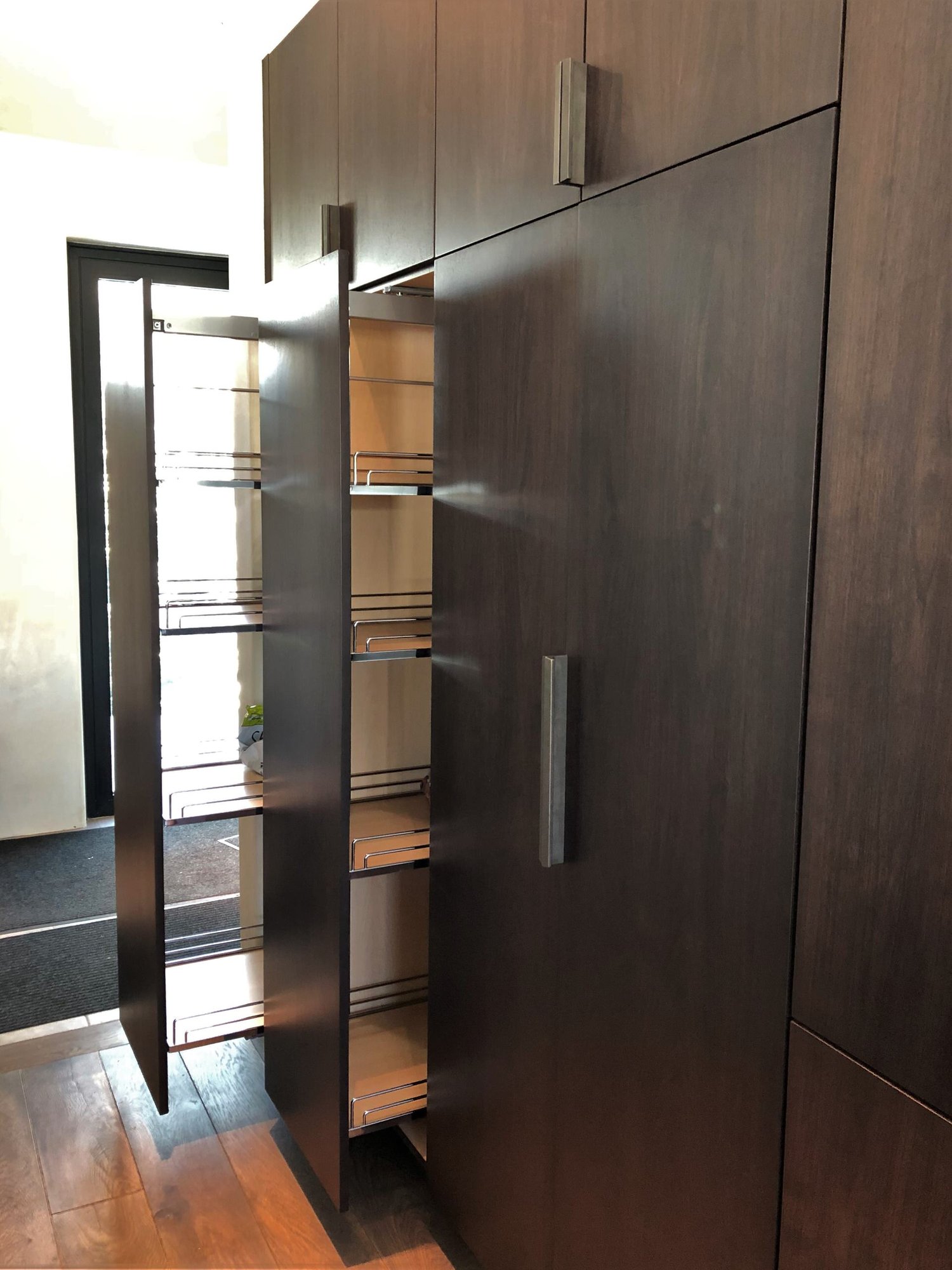 Large trendy galley medium tone wood floor, brown floor and vaulted ceiling open concept kitchen with an undermount sink, flat-panel cabinets, dark wood cabinets, colored appliances, an island and multicolored countertops, by Jensen Design in Telluride, CO