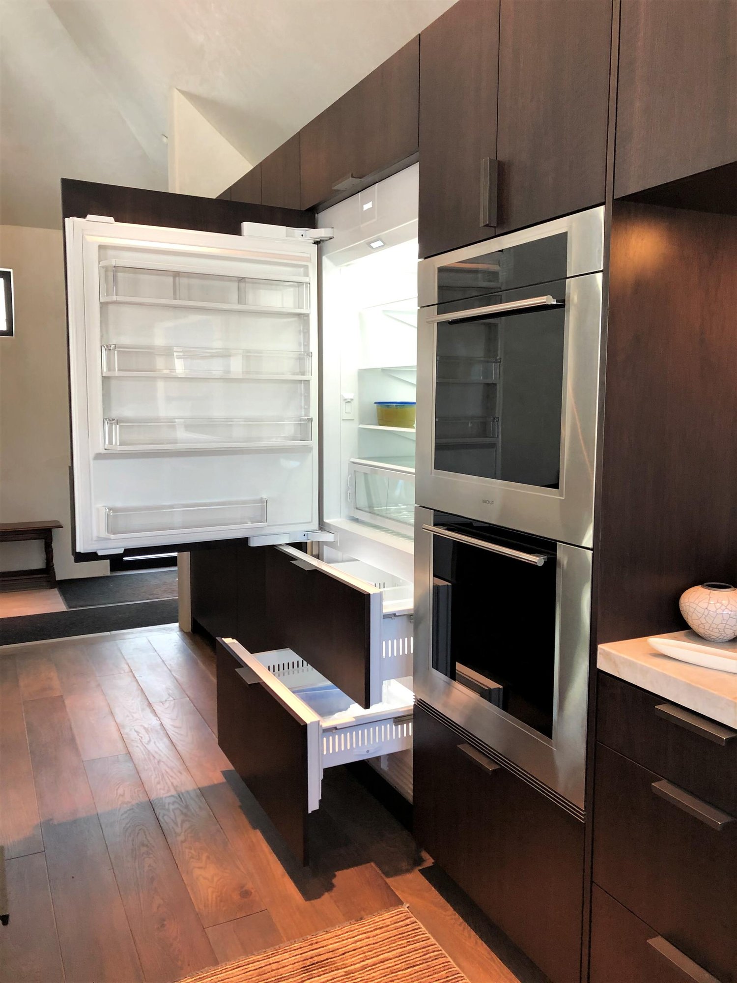 Large contemporary galley medium tone wood floor, brown floor and vaulted ceiling open concept kitchen with an undermount sink, flat-panel cabinets, dark wood cabinets, colored appliances, an island and multicolored countertops, by Jensen Design in Telluride, CO