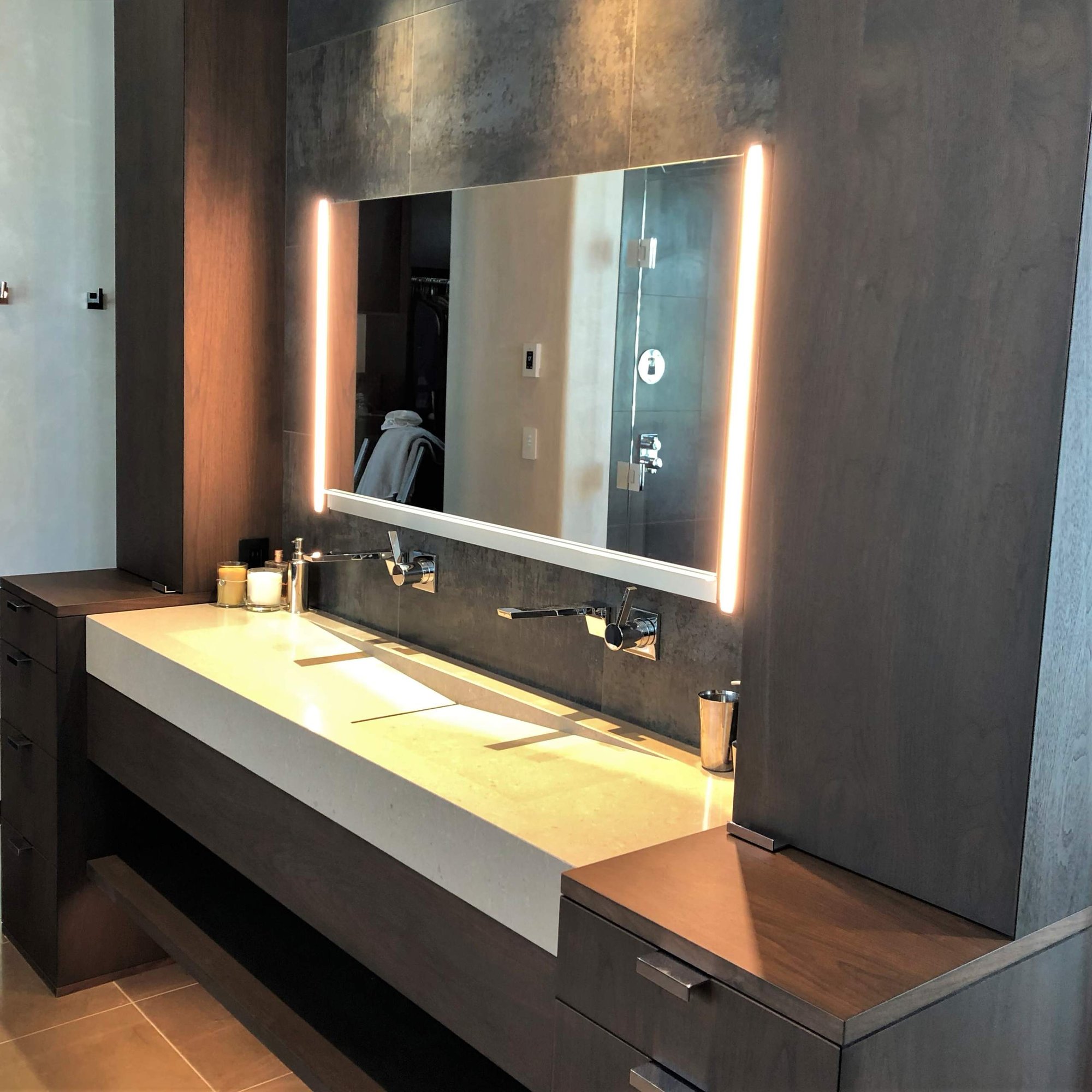 Mid-sized trendy master gray tile brown floor and double-sink bathroom with flat-panel cabinets, dark wood cabinets, beige walls, a trough sink, a hinged shower door, beige countertops and a built-in vanity, by Jensen Design in Telluride, CO