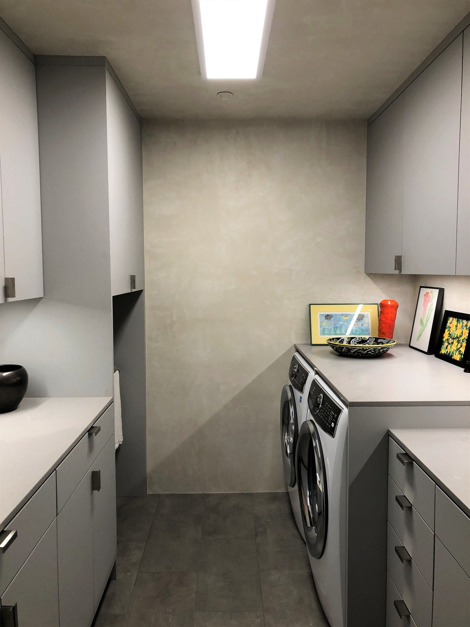 Mid-sized trendy galley gray floor dedicated laundry room with an undermount sink, flat-panel cabinets, gray cabinets, beige walls, a side-by-side washer/dryer and gray countertops, by Jensen Design in Telluride, CO