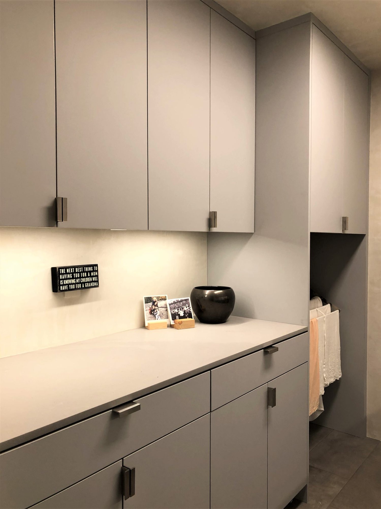 Mid-sized trendy galley gray floor dedicated laundry room with an undermount sink, flat-panel cabinets, gray cabinets, beige walls, a side-by-side washer/dryer and gray countertops, by Jensen Design in Telluride, CO