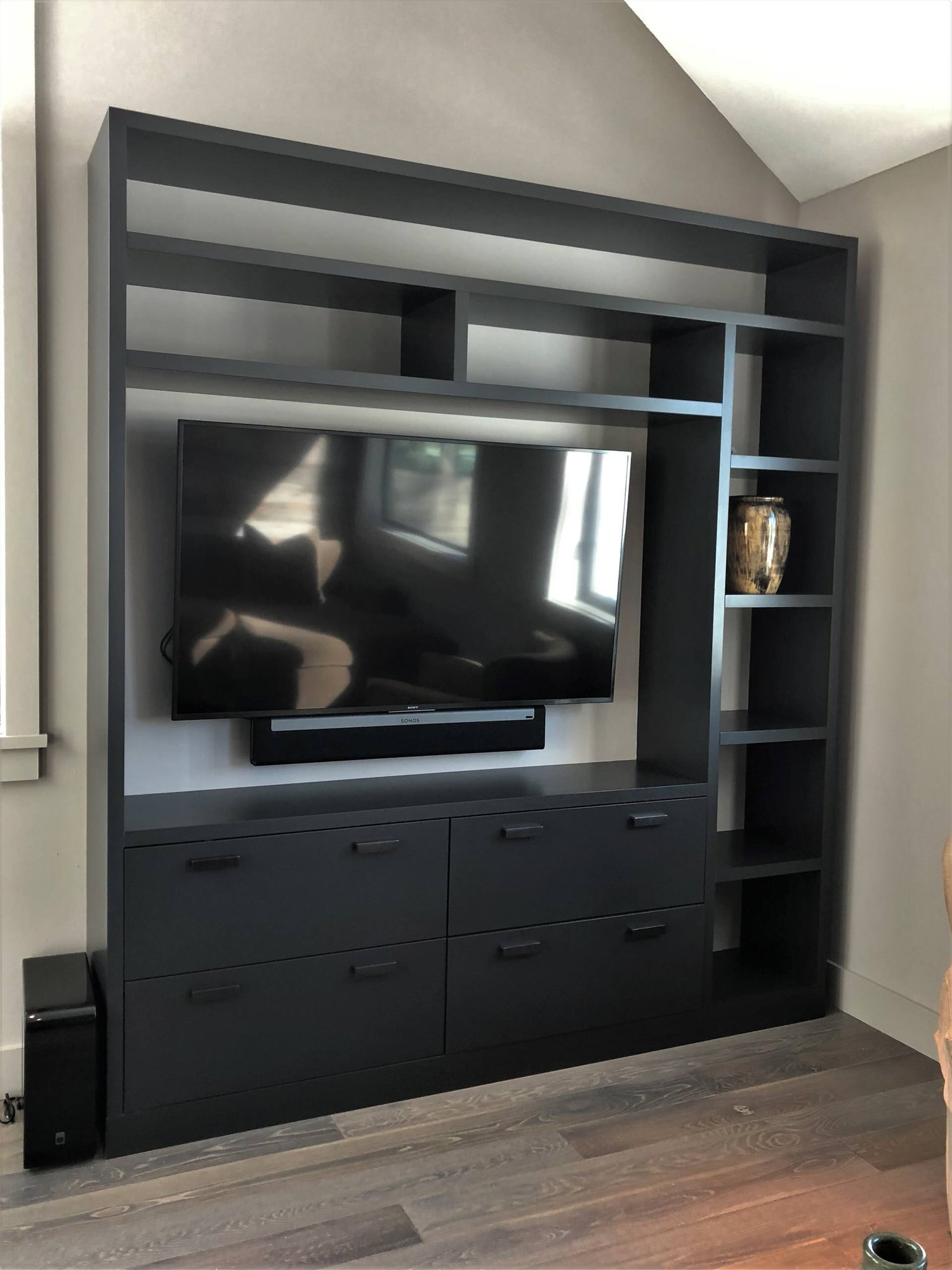 Mid-sized contemporary open concept medium tone wood floor and brown floor living room with beige walls, no fireplace and a media wall, by Jensen Design in Telluride, CO