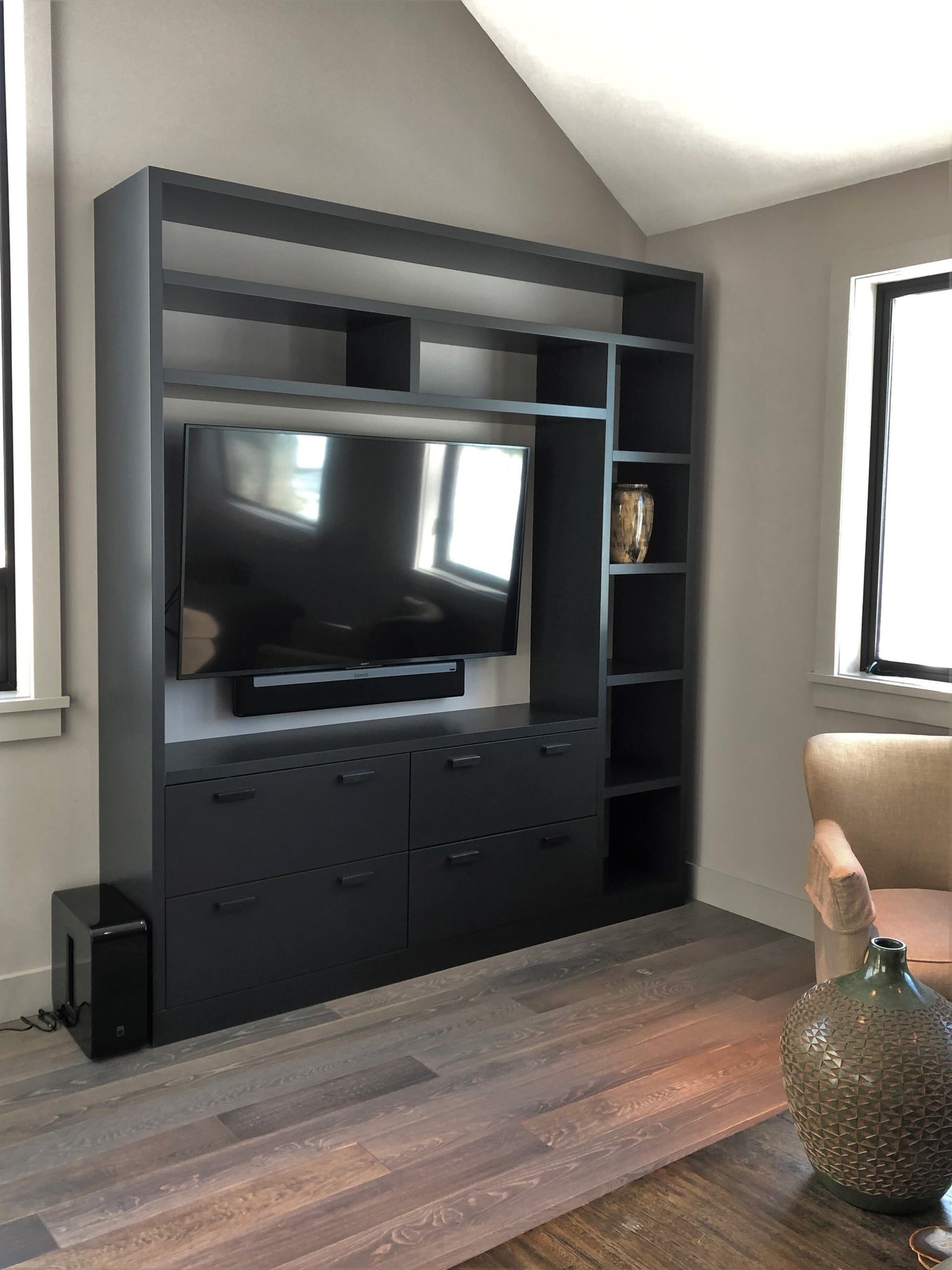 Mid-sized trendy open concept medium tone wood floor and brown floor living room with beige walls, no fireplace and a media wall, by Jensen Design in Telluride, CO