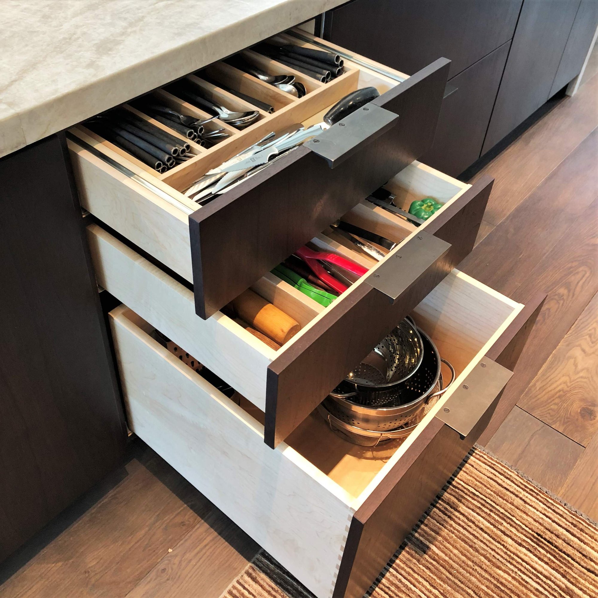 Large trendy galley medium tone wood floor, brown floor and vaulted ceiling open concept kitchen with an undermount sink, flat-panel cabinets, dark wood cabinets, colored appliances, an island and multicolored countertops, by Jensen Design in Telluride, CO