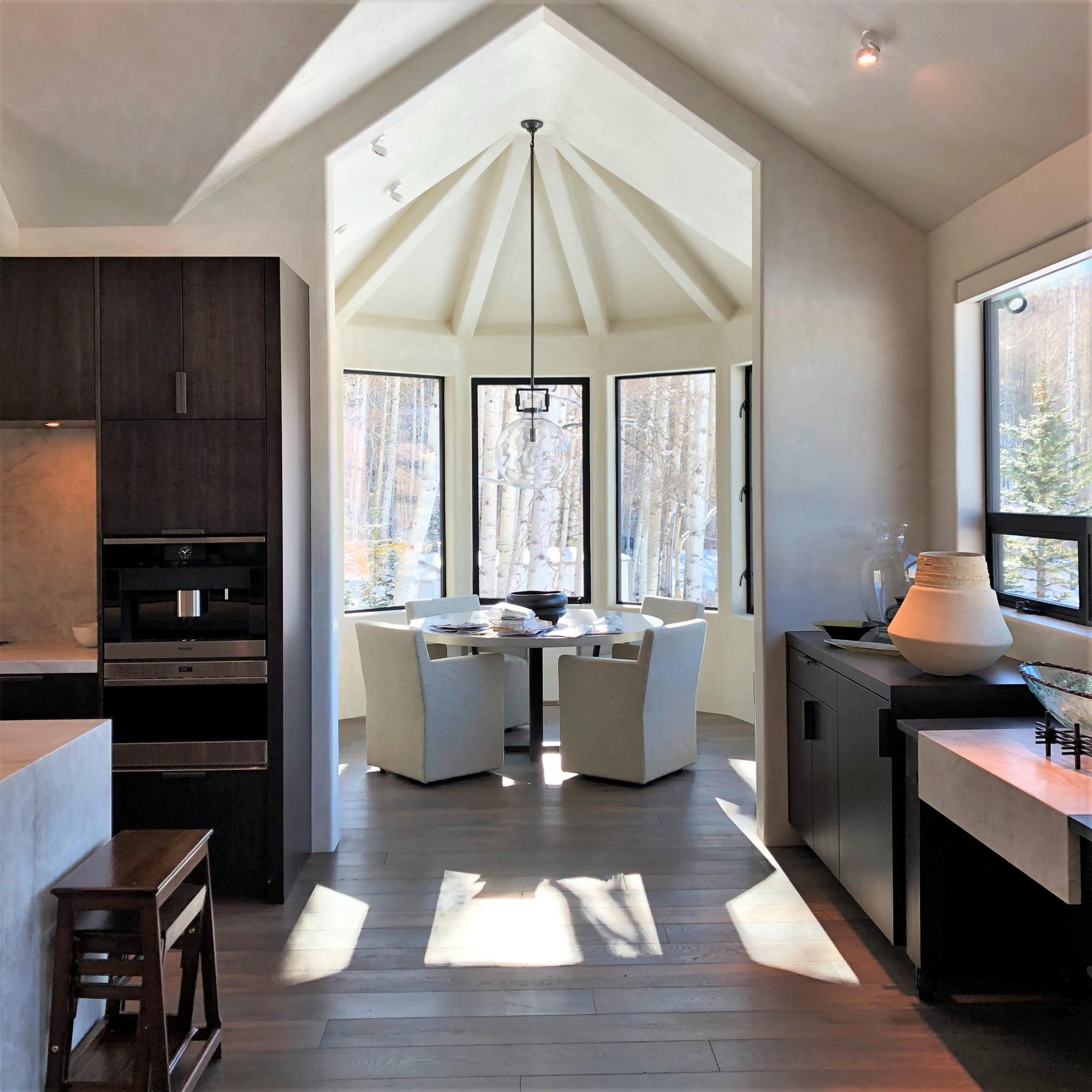 Large trendy galley medium tone wood floor, brown floor and vaulted ceiling open concept kitchen with an undermount sink, flat-panel cabinets, dark wood cabinets, multicolored backsplash, colored appliances, an island and multicolored countertops, by Jensen Design in Telluride, CO