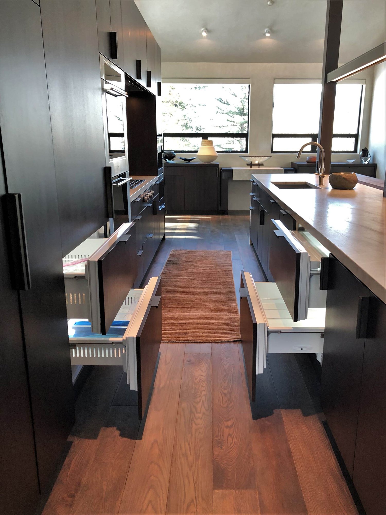 Large contemporary galley medium tone wood floor, brown floor and vaulted ceiling open concept kitchen with an undermount sink, flat-panel cabinets, dark wood cabinets, colored appliances, an island and multicolored countertops, by Jensen Design in Telluride, CO
