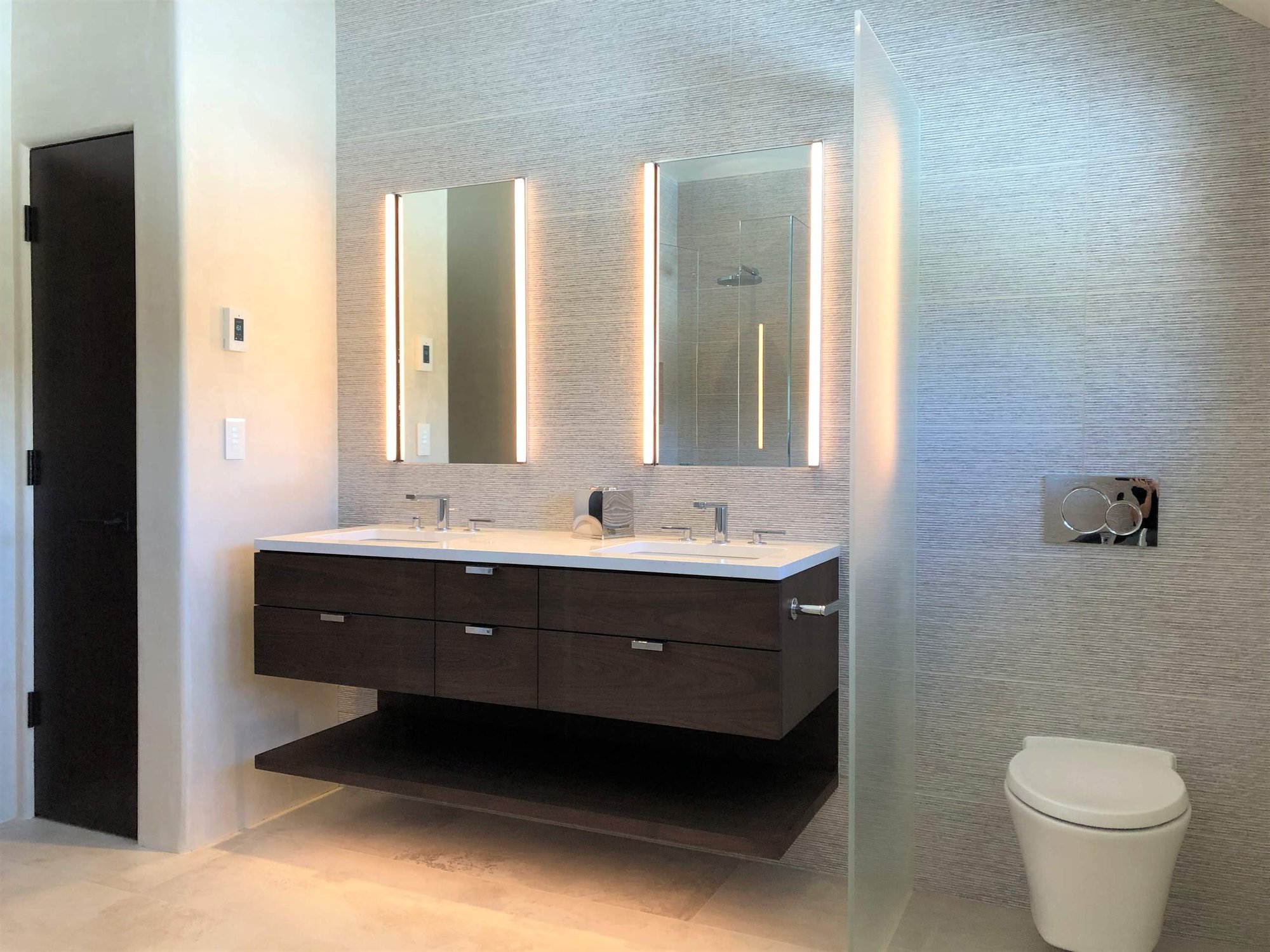 Mid-sized trendy master gray tile beige floor, double-sink and vaulted ceiling bathroom with flat-panel cabinets, dark wood cabinets, a wall-mount toilet, gray walls, an undermount sink, white countertops and a floating vanity, by Jensen Design in Telluride, CO