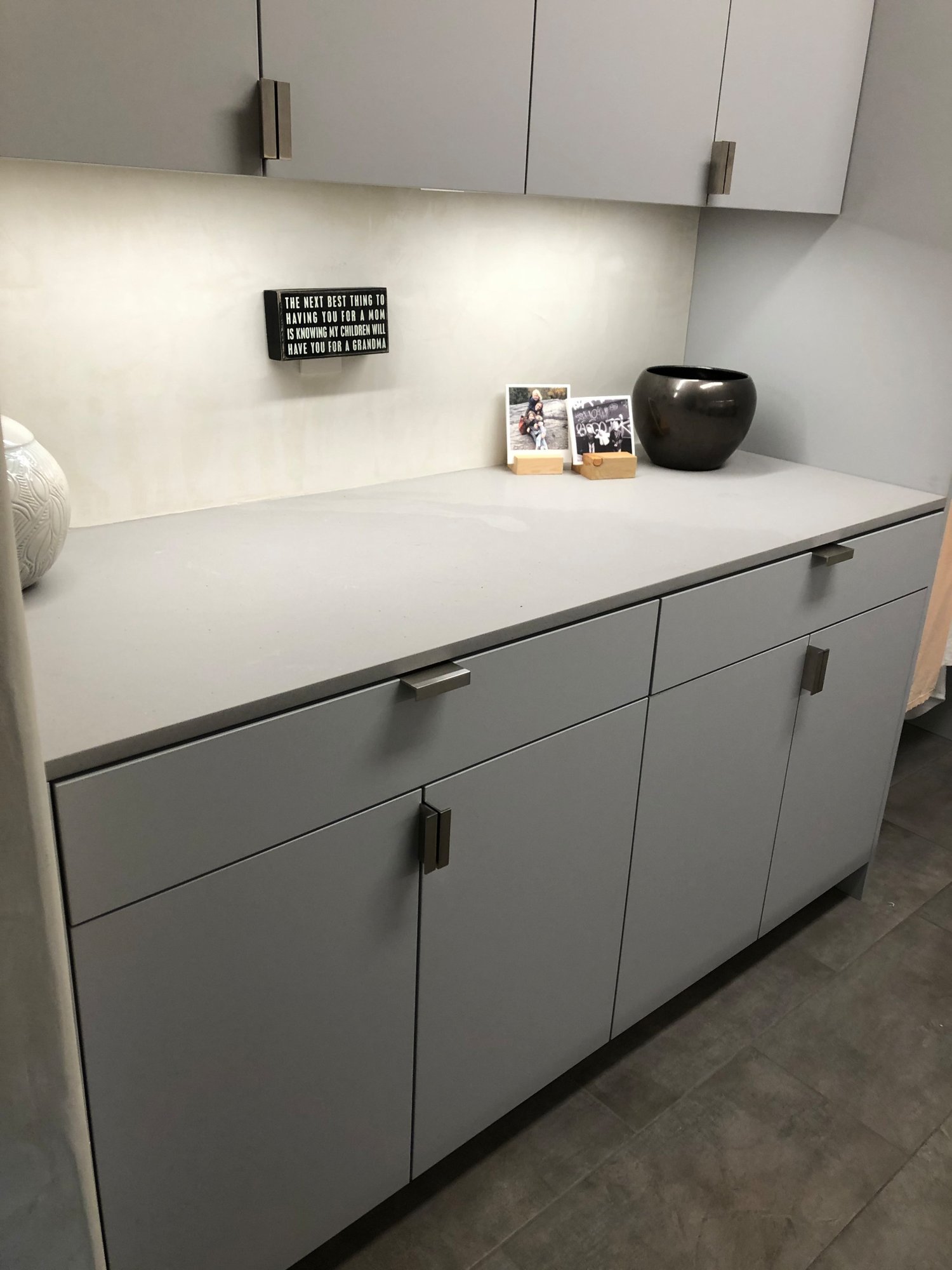 Mid-sized contemporary galley gray floor dedicated laundry room with an undermount sink, flat-panel cabinets, gray cabinets, beige walls, a side-by-side washer/dryer and gray countertops, by Jensen Design in Telluride, CO
