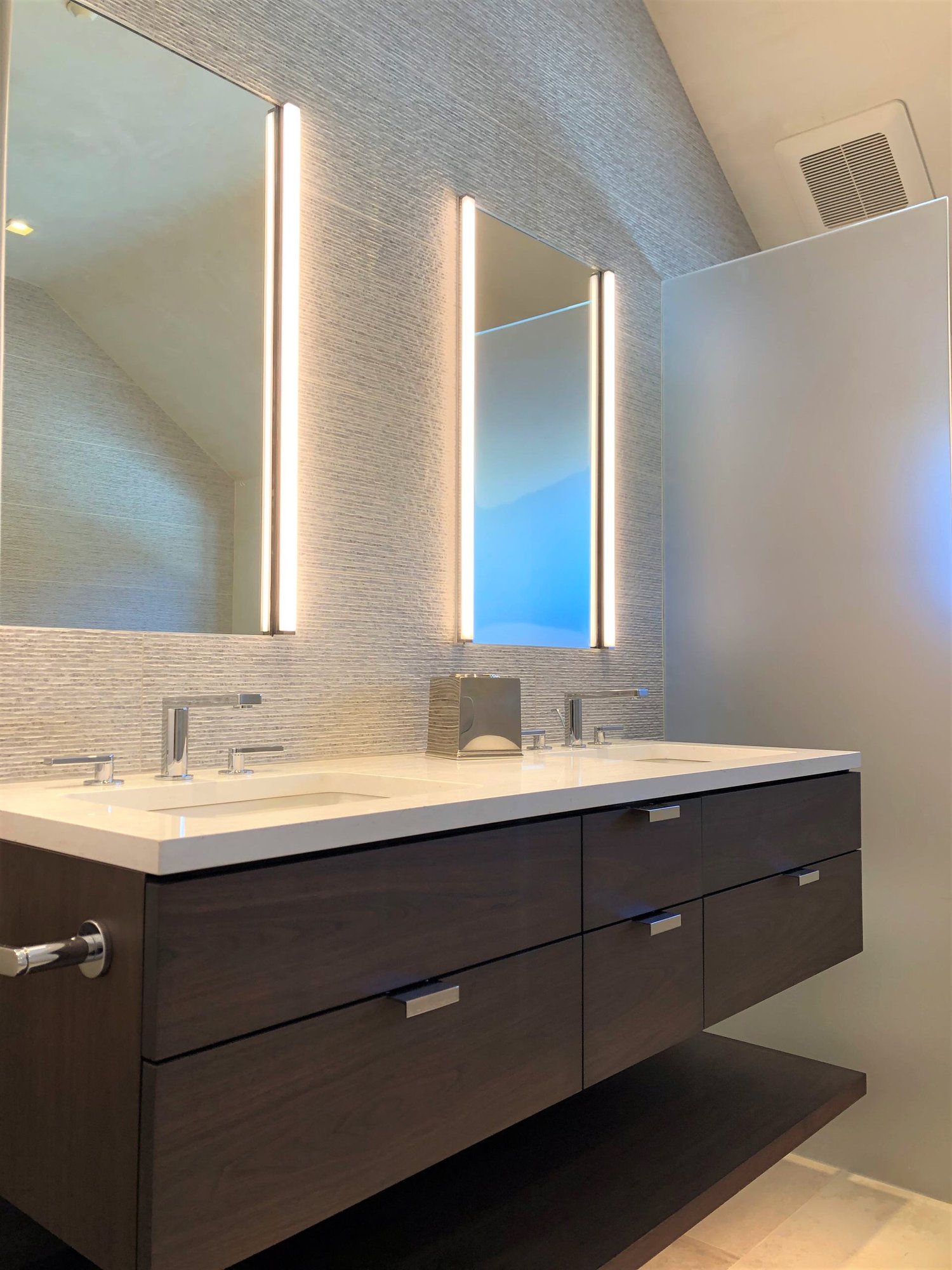 Mid-sized trendy master gray tile beige floor, double-sink and vaulted ceiling bathroom with flat-panel cabinets, dark wood cabinets, gray walls, an undermount sink, white countertops and a floating vanity, by Jensen Design in Telluride, CO