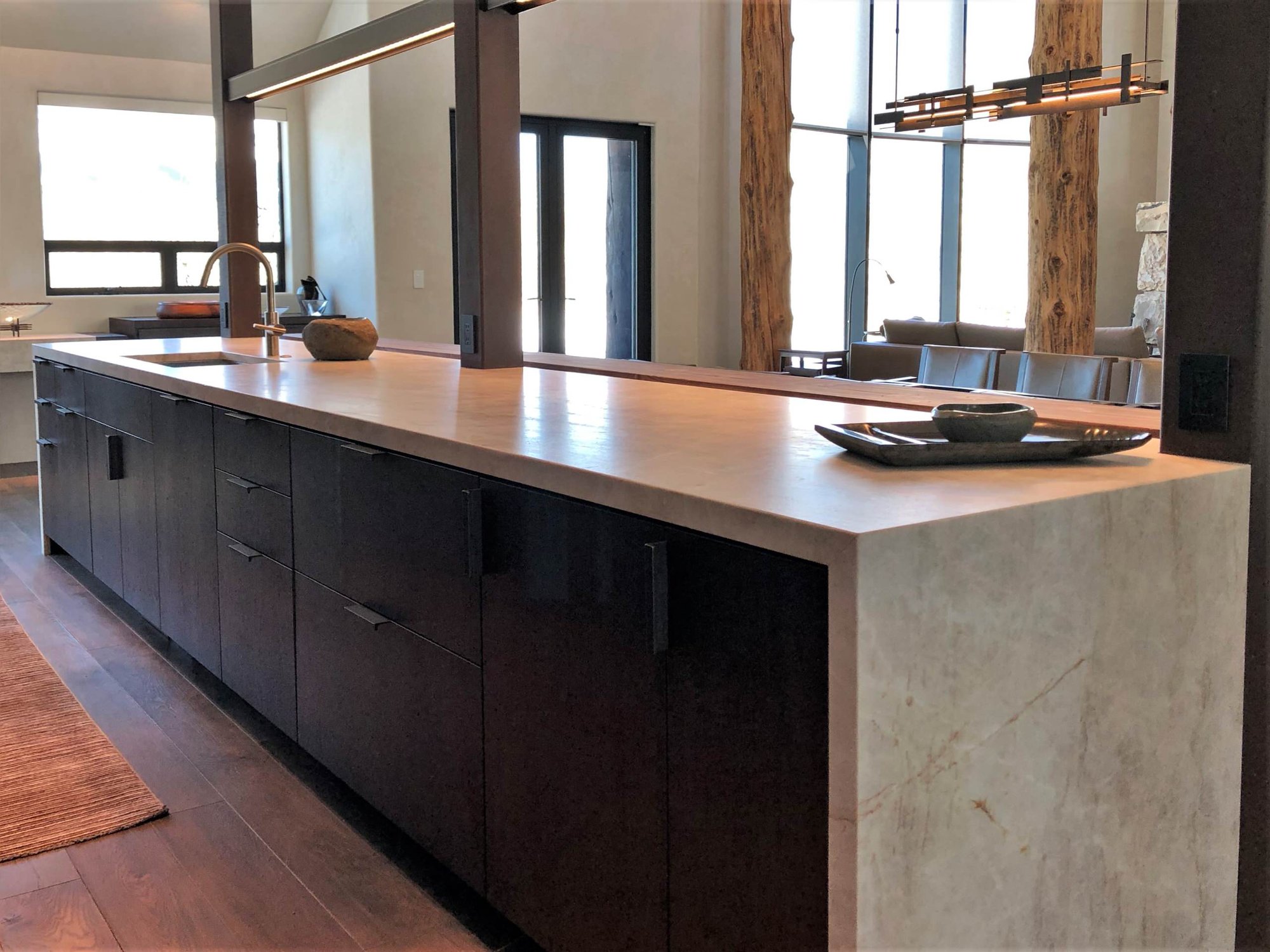 Large trendy galley medium tone wood floor, brown floor and vaulted ceiling open concept kitchen with an undermount sink, flat-panel cabinets, dark wood cabinets, colored appliances, an island and multicolored countertops, by Jensen Design in Telluride, CO